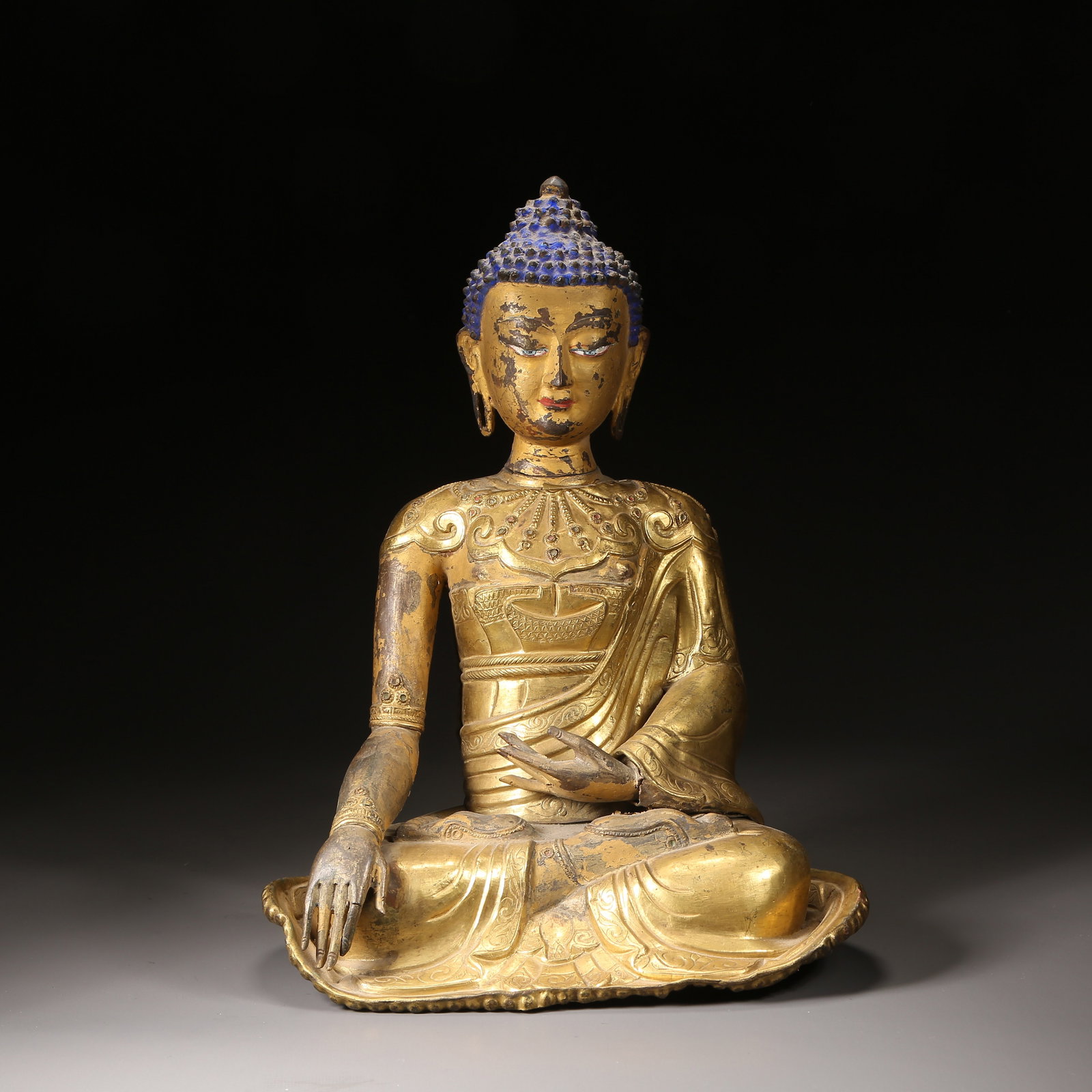 A QING DYNASTY GILT-BRONZE HAMMER-FINISHED SHAKYAMUNI STATUE: Qing dynasty gilt-bronze hammer-finished Shakyamuni statue