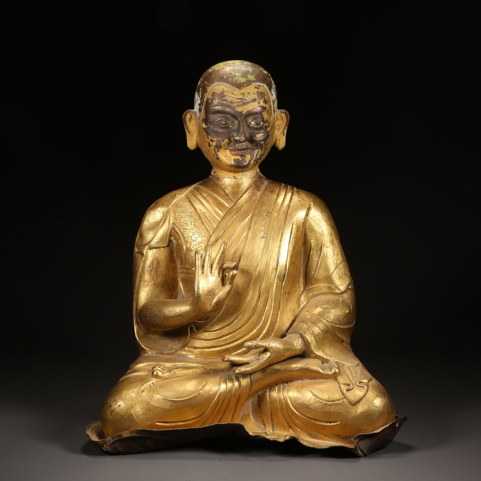 A QING DYNASTY GILT-BRONZE HAMMER-FINISHED LAMA STATUE (1 of 8)