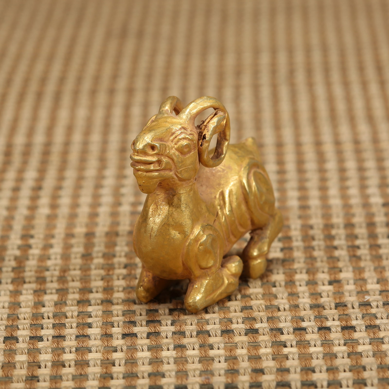 A LIAO–JIN DYNASTY PURE GOLD RECLINING SHEEP ORNAMENT: Liao–Jin dynasty pure gold reclining sheep ornament