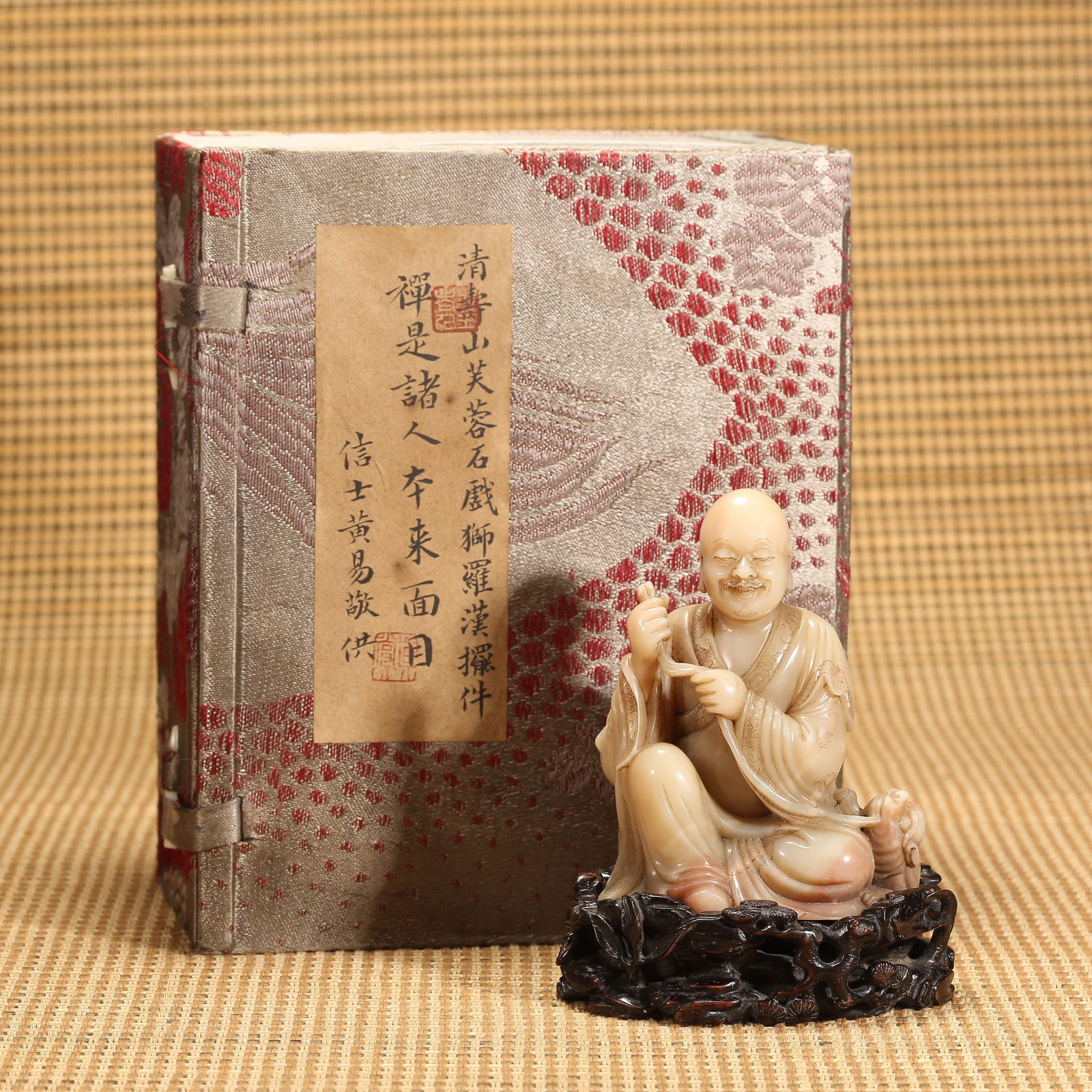 A QING DYNASTY SHOUSHAN FURONG STONE ORNAMENT OF ARHAT PLAYING WITH LION: Qing Dynasty Shoushan Furong Stone Ornament of Arhat Playing with Lion