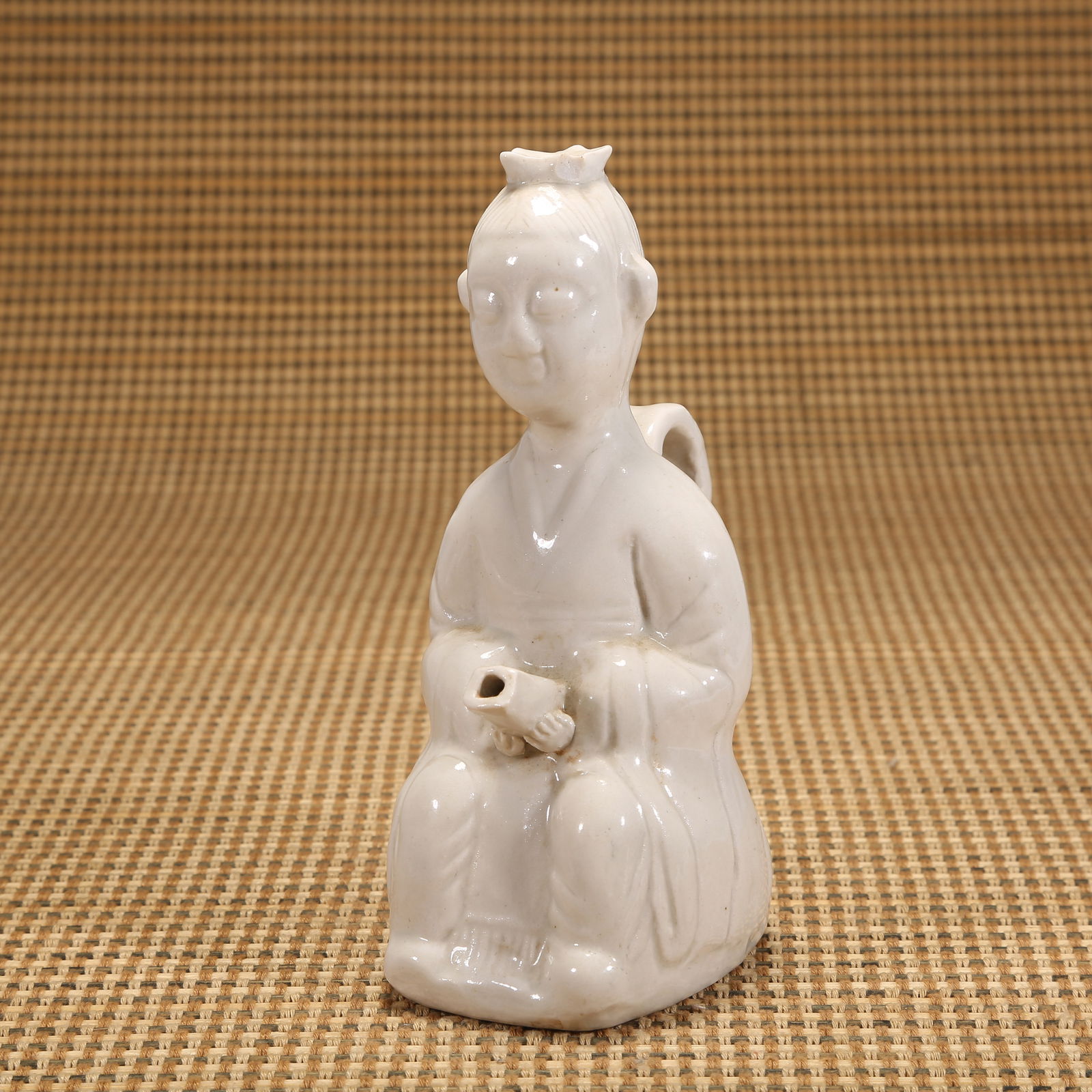 A SONG DYNASTY DING KILN BOY HOLDING EWER: Song dynasty Ding kiln boy holding ewer