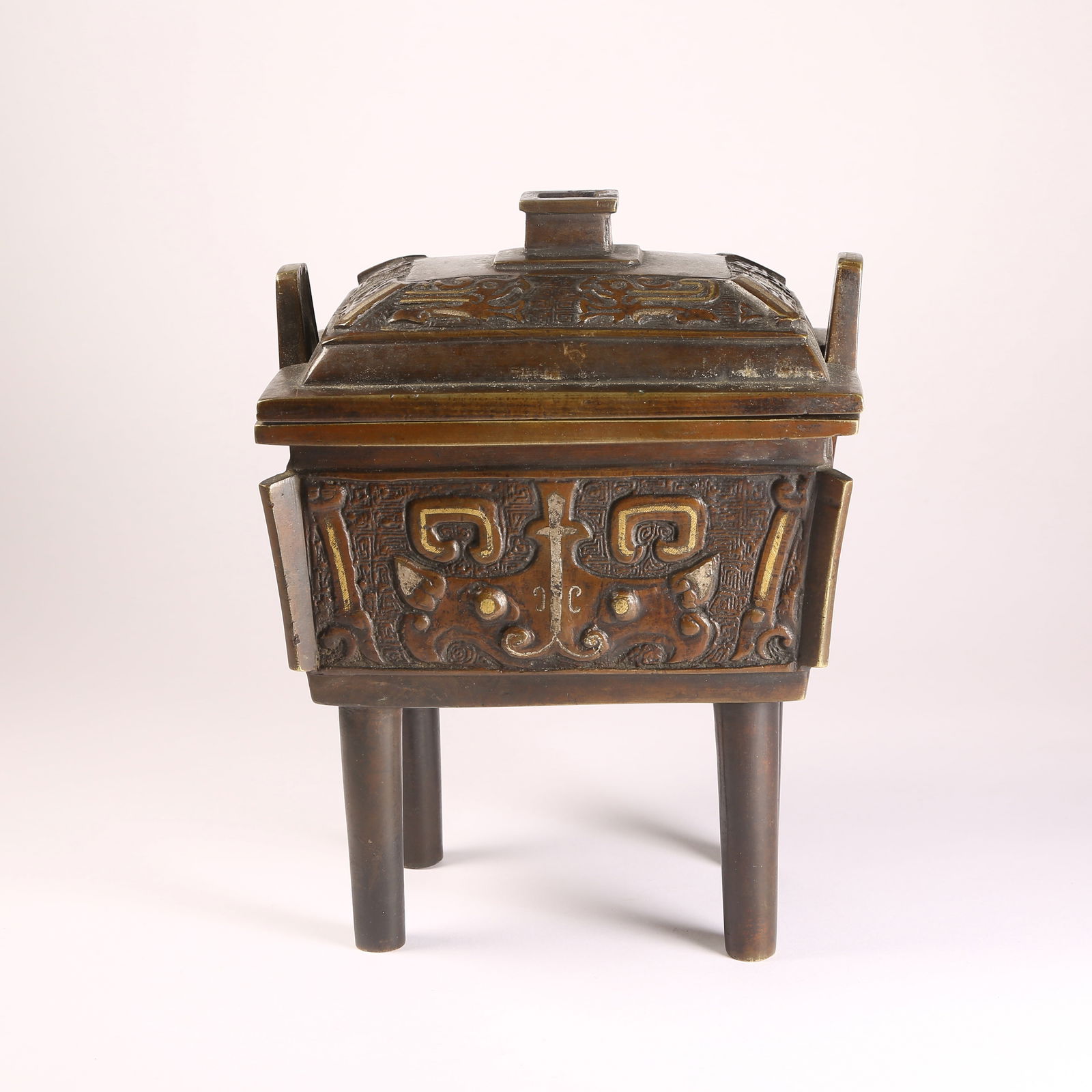 A BRONZE INLAY WITH GOLD AND SILVER FOUR-FOOTED CENSER WITH BEAST-HEAD AND HALBERD MOTIFS: Bronze Inlay with Gold and Silver Four-Footed Censer with Beast-Head and Halberd Motifs