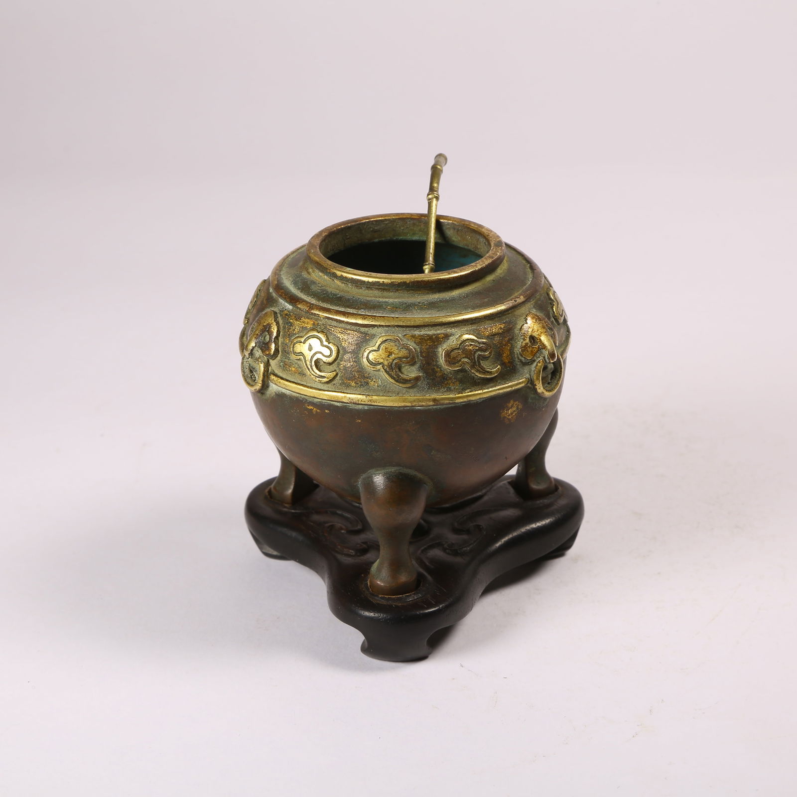 A GILT BRONZE TRIPOD WATER CONTAINER WITH FU-HEADED HANDLES AND AUSPICIOUS CLOUD MOTIF: Gilt Bronze Tripod Water Container with Fu-Headed Handles and Auspicious Cloud Motif