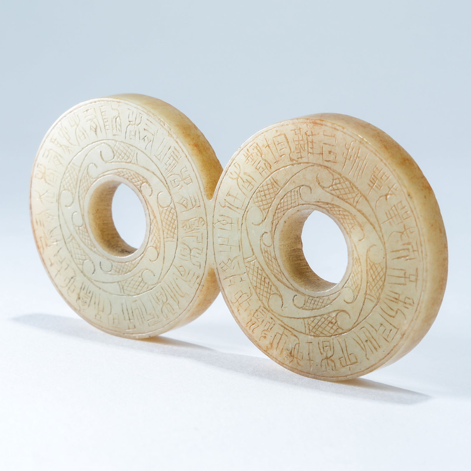 A HETIAN JADE CARVED DOUBLE-LINKED SMALL BI DISCS: Hetian Jade Carved Double-Linked Small Bi Discs