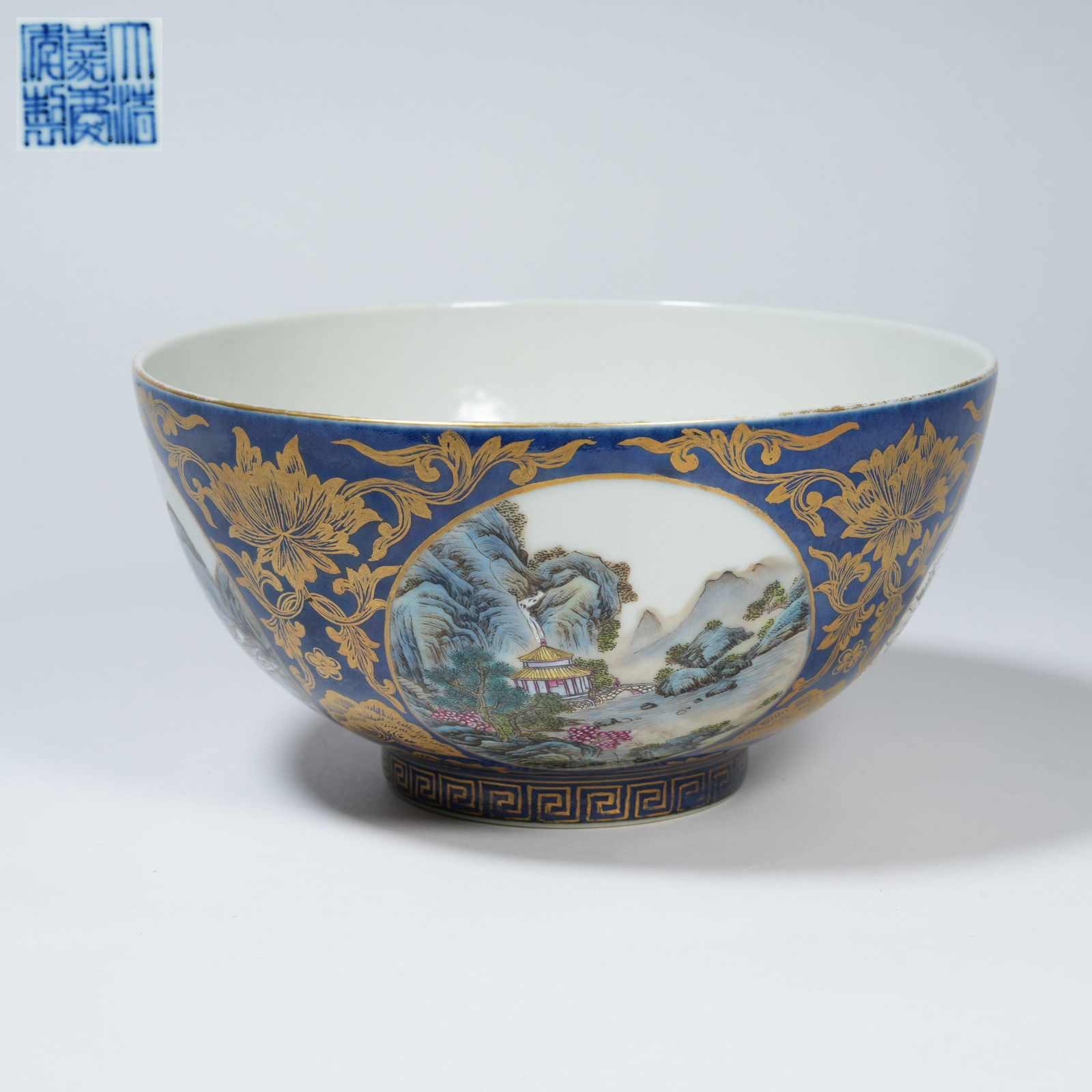A BLUE-GROUND FAMILLE-ROSE BOWL WITH PANELLED FOUR-SEASON LANDSCAPE DECORATION, GILT-DECORATED: Blue-Ground Famille-Rose Bowl with Panelled Four-Season Landscape Decoration, Gilt-Decorated