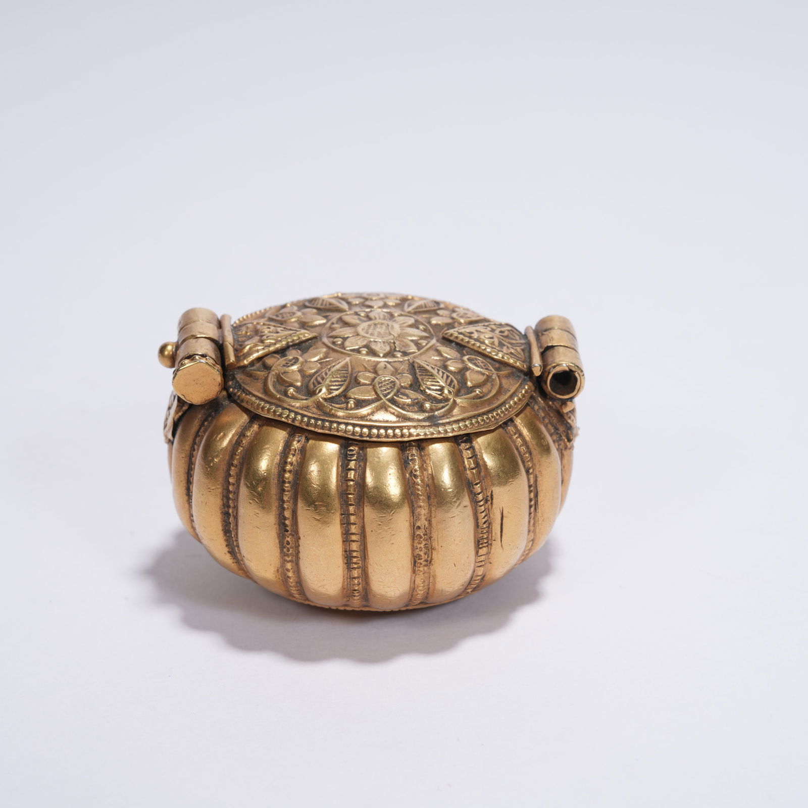 A BRONZE GAWU AMULET BOX WITH MELON-LOBED FORM AND FLORAL DECORATION (1 of 9)