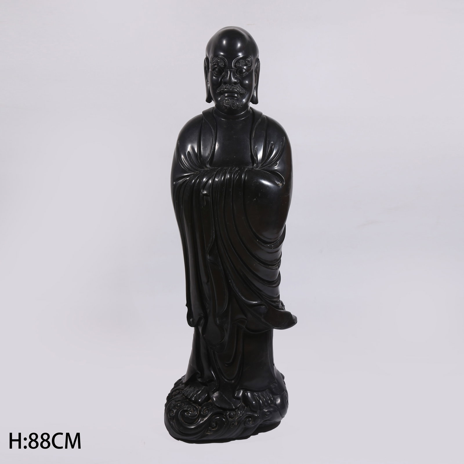 A BLACK STONE STANDING FIGURE OF BODHIDHARMA: Black stone standing figure of Bodhidharma