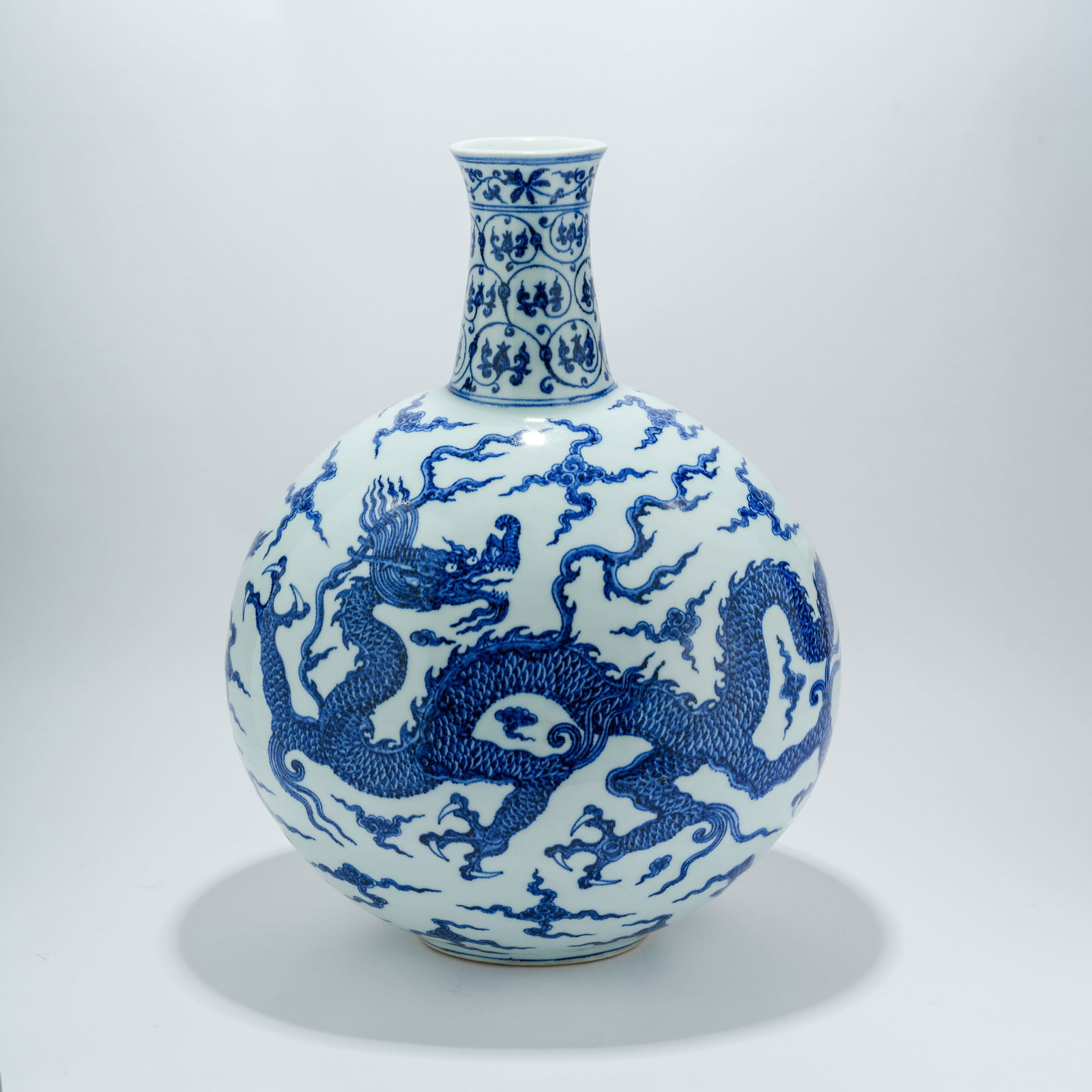 A BLUE-AND-WHITE MOONFLASK WITH CLOUD-AND-DRAGON DESIGN: Blue-and-White Moonflask with Cloud-and-Dragon Design