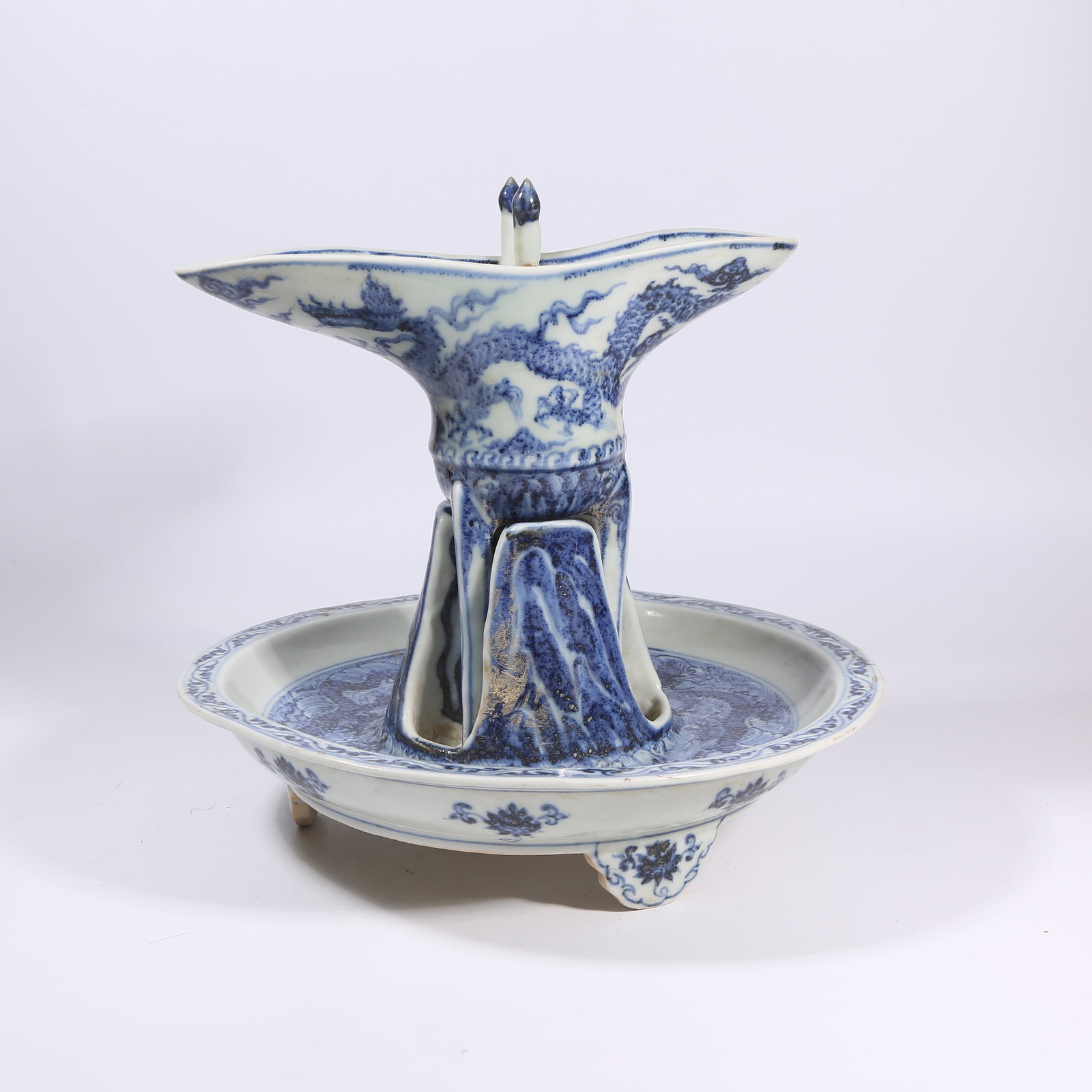 A BLUE-AND-WHITE JUE CUP WITH "CLIFF, WAVES, AND DRAGON" MOTIFS: Blue-and-White Jue Cup with "Cliff, Waves, and Dragon" Motifs