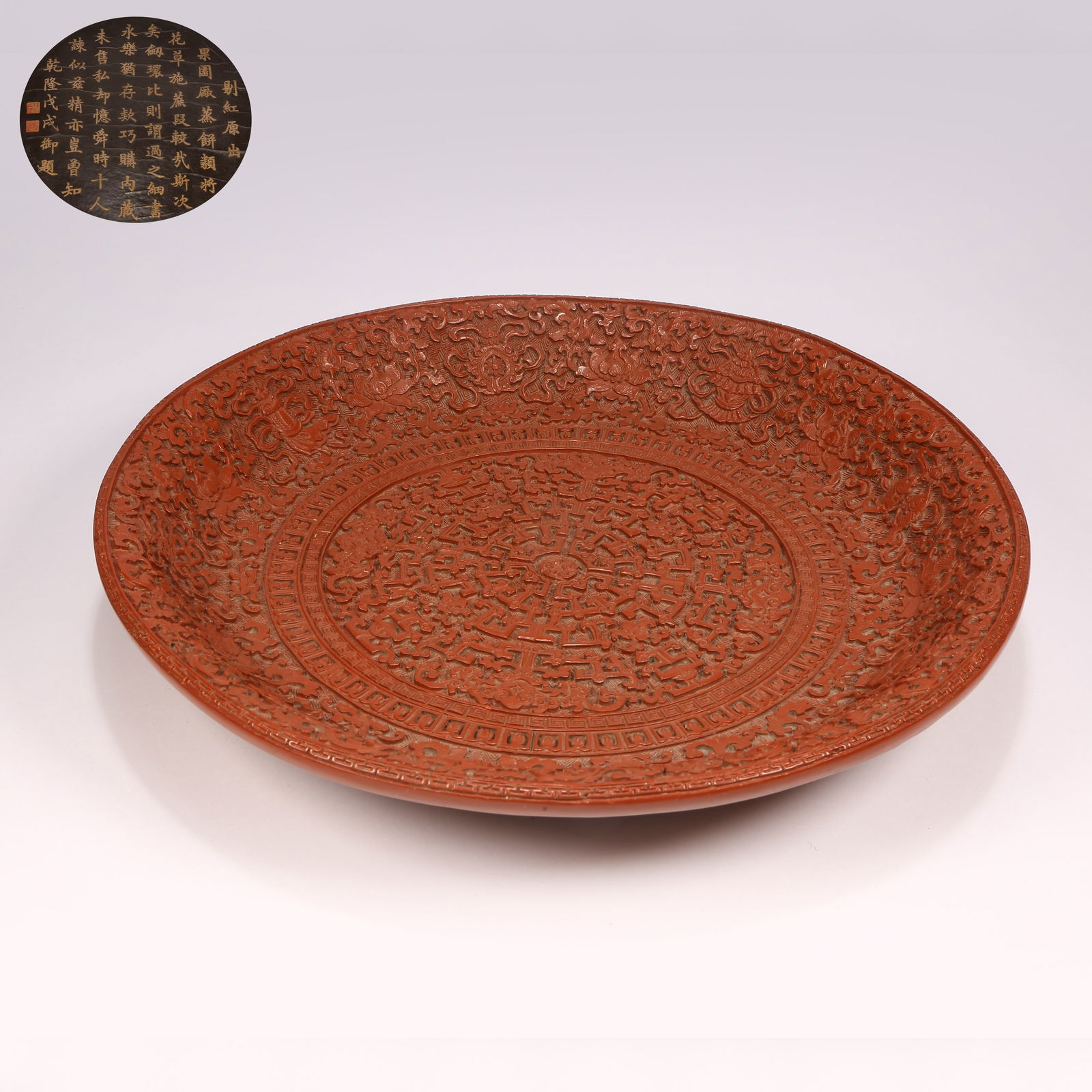 A CARVED RED-LACQUER DISH WITH SCROLLING LOTUS AND EIGHT AUSPICIOUS SYMBOLS: Carved red-lacquer dish with scrolling lotus and Eight Auspicious Symbols