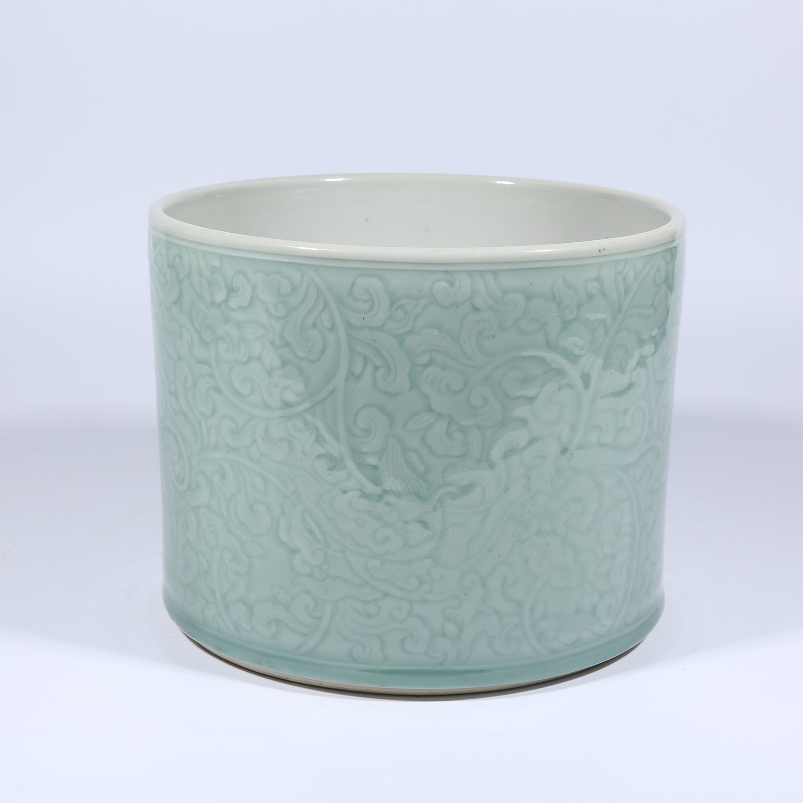 A CELADON-GLAZED BRUSH POT WITH CLOUD-AND-DRAGON DESIGN: Celadon-glazed Brush Pot with Cloud-and-Dragon Design