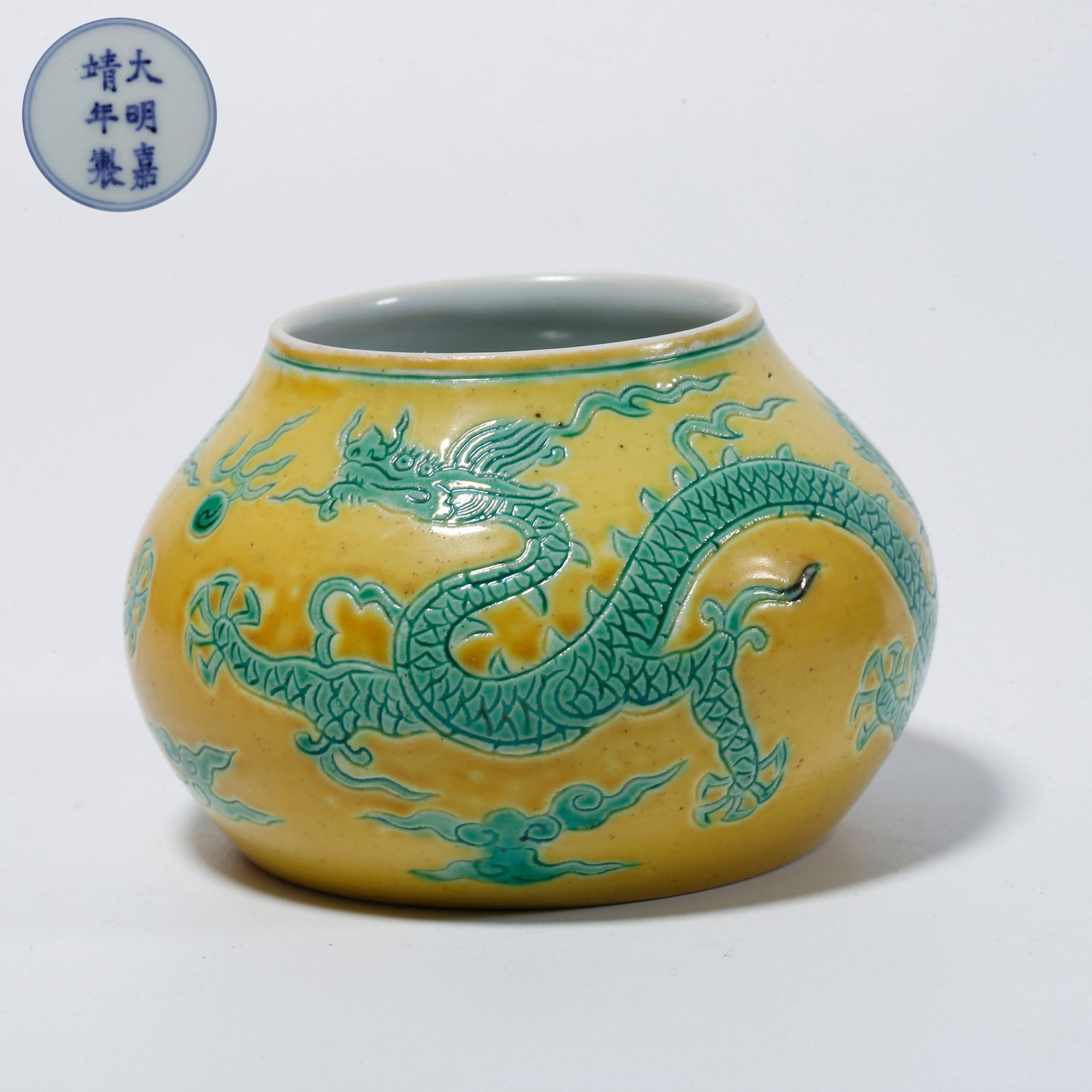 A YELLOW-GLAZED CARVED JAR WITH CLOUD AND DRAGON DESIGN: Yellow-glazed carved jar with cloud and dragon design