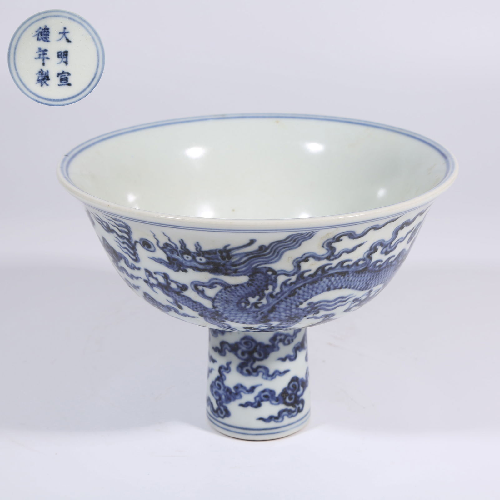 A BLUE AND WHITE TALL-FOOTED BOWL WITH CLOUD AND DRAGON "PEARL-CHASING" MOTIF: Blue and White Tall-Footed Bowl with Cloud and Dragon "Pearl-Chasing" Motif