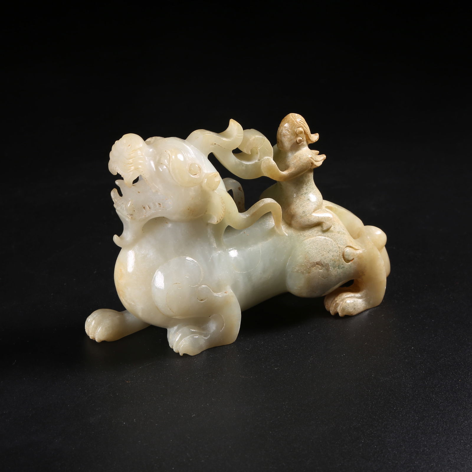 A ARCHAIC JADE FEATHERED FIGURE RIDING BEAST FIGURINE: Archaic Jade Feathered Figure Riding Beast Figurine