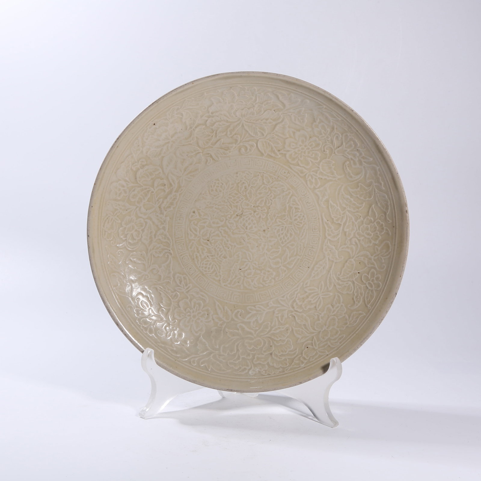 A DING KILN CARVED FLORAL PATTERNED DISH: Ding kiln carved floral patterned dish
