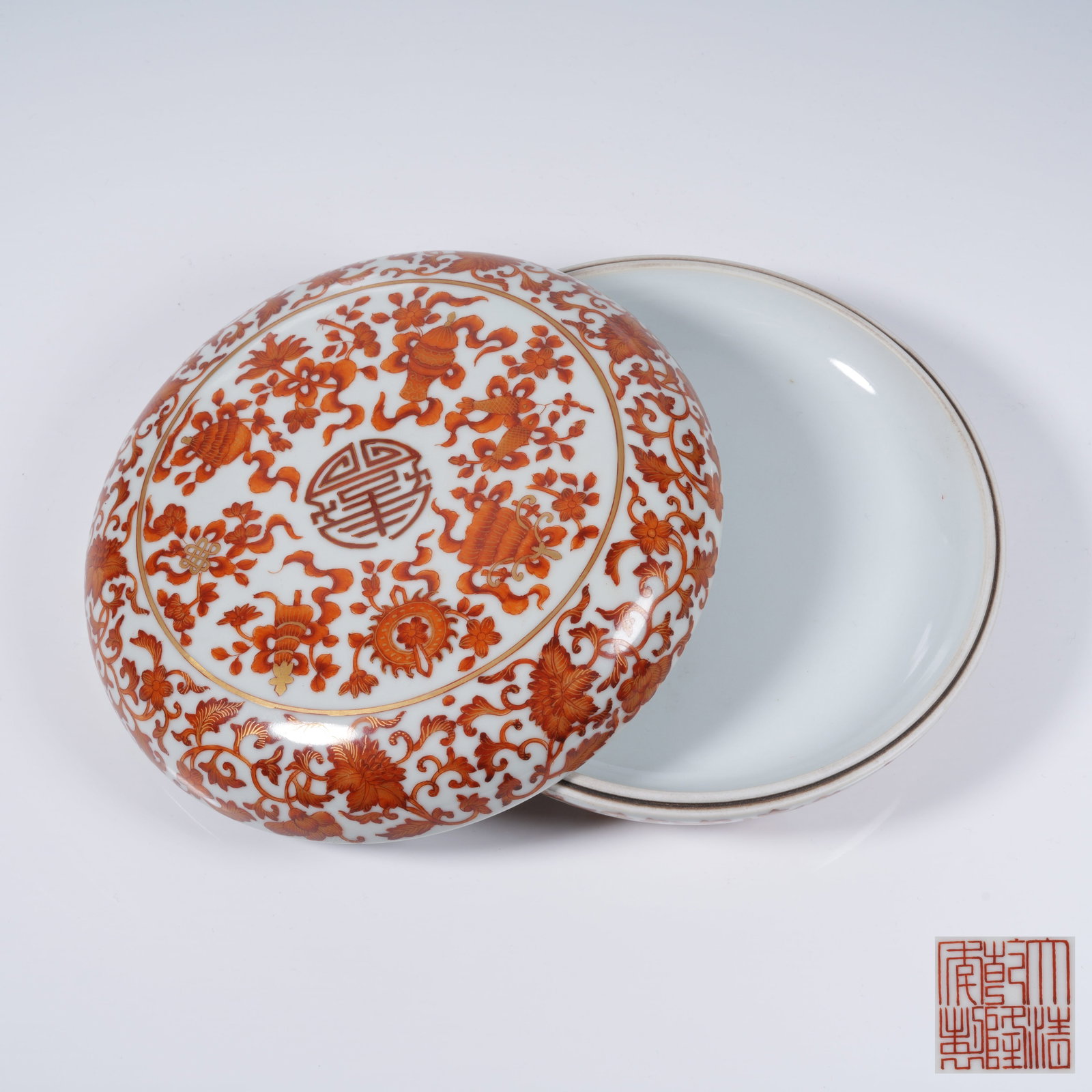 A IRON RED GILT ROUND BOX WITH INTERLOCKING FLORAL AND EIGHT TREASURES PATTERN: Iron Red Gilt Round Box with Interlocking Floral and Eight Treasures Pattern