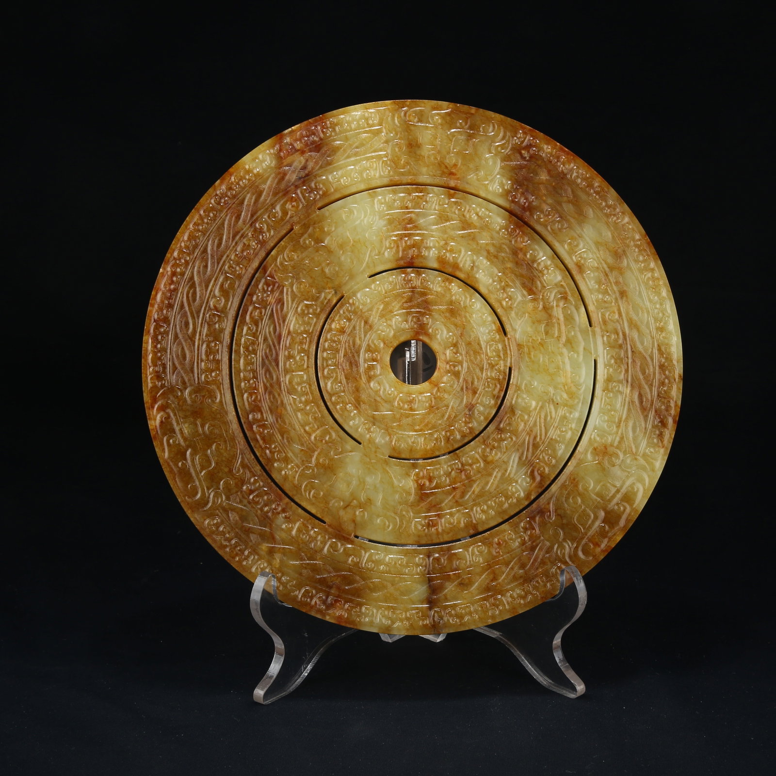 A ARCHAIC JADE BI DISC WITH BEAST FACE PATTERN: Archaic Jade Bi Disc with Beast Face Pattern