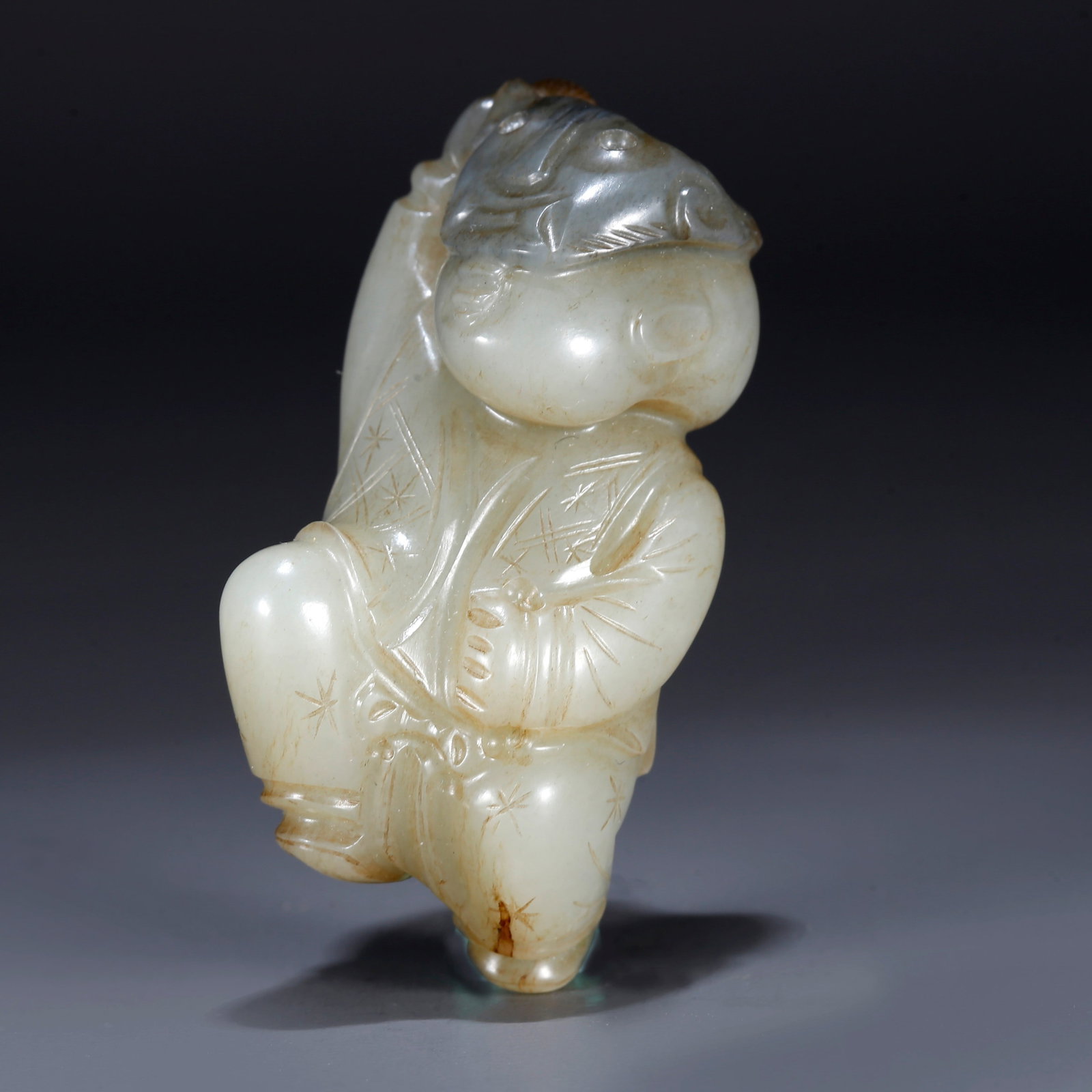 A HETIAN JADE CARVING OF A CHILD FIGURINE: Hetian Jade Carving of a Child Figurine