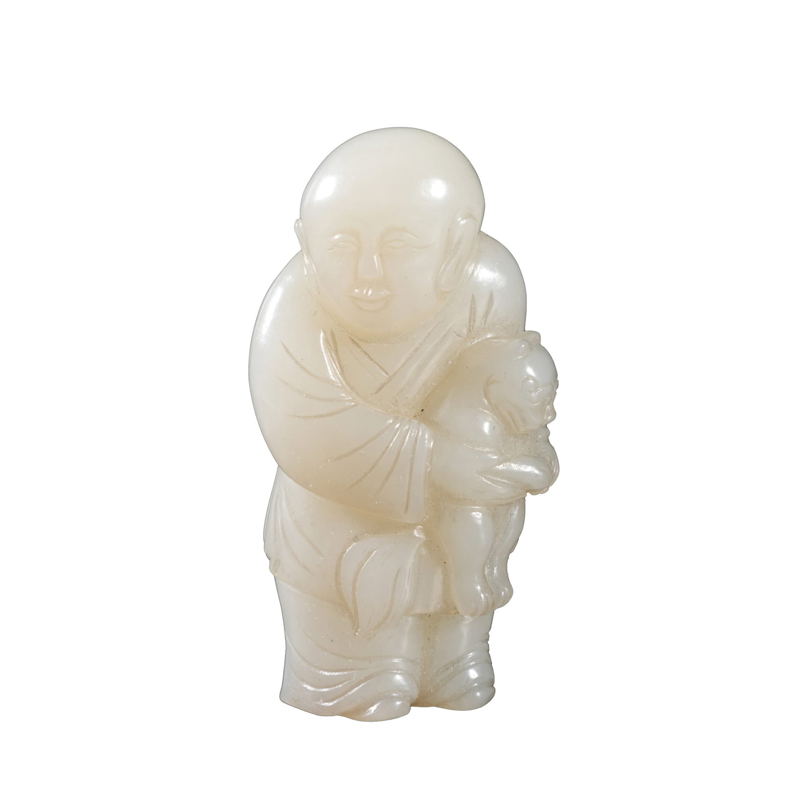HETIAN WHITE JADE BOY HOLDING MYTHICAL BEAST, QING DYNASTY: The jade is pale white and mellow, with a plump and rounded boy figure holding an auspicious beast in arms and wearing a joyful serene expression. Garment folds are rendered in concise crisp lines; th