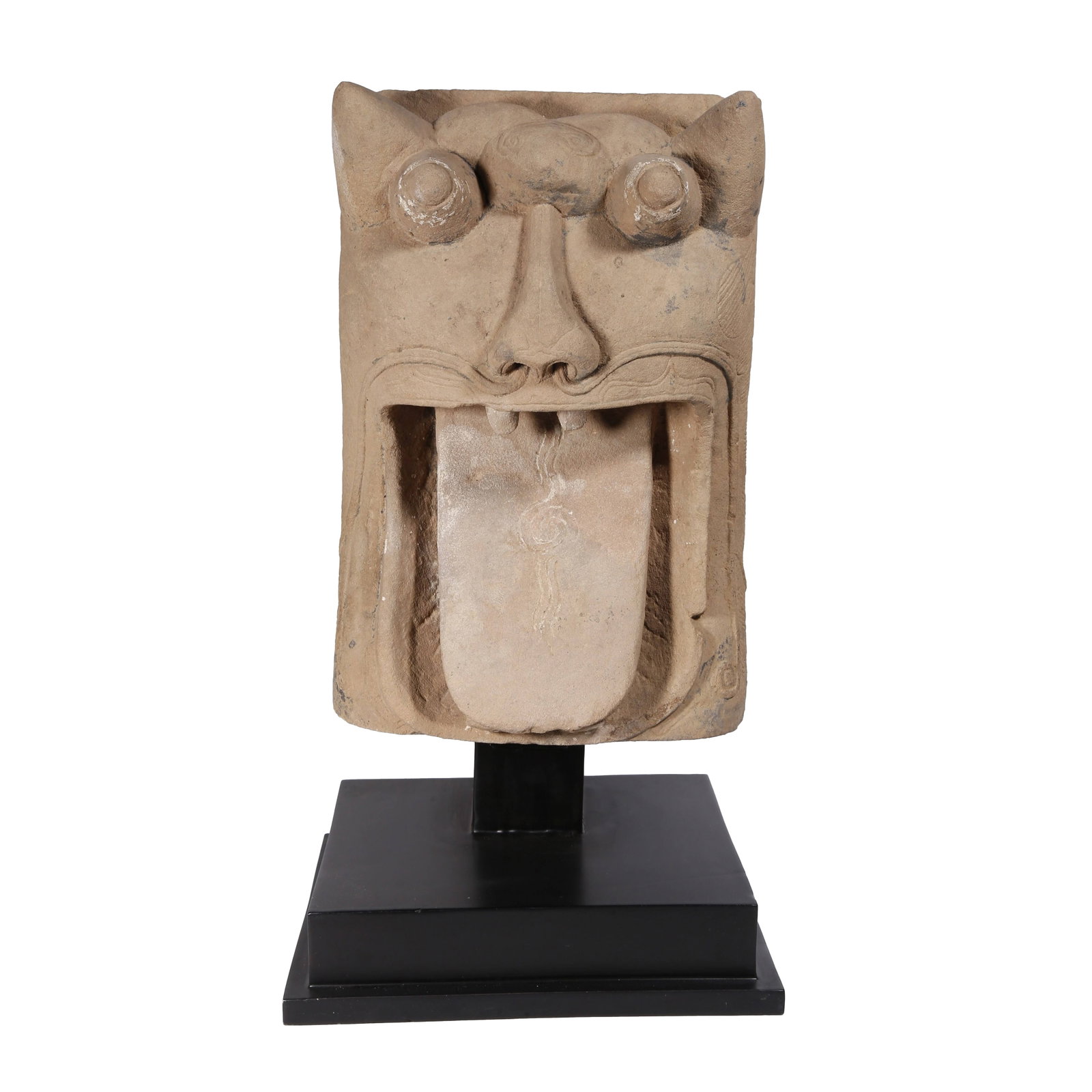 SANDSTONE BEAST-MASK DOOR KNOCKER, HAN DYNASTY: Han Dynasty sandstone carved beast mask with bulging round eyes and wide open mouth sticking out its tongue, imposing and archaic in shape with concise, bold lines. It served as an evil-averting archi