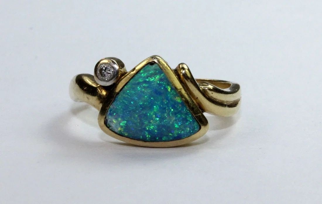 MODERN DESIGN OPAL RING IN 18CT YELLOW GOLD OFFSET BY A SMALL DIAMOND: Modern design Opal Ring in 18ct Yellow Gold offset by a small Diamond