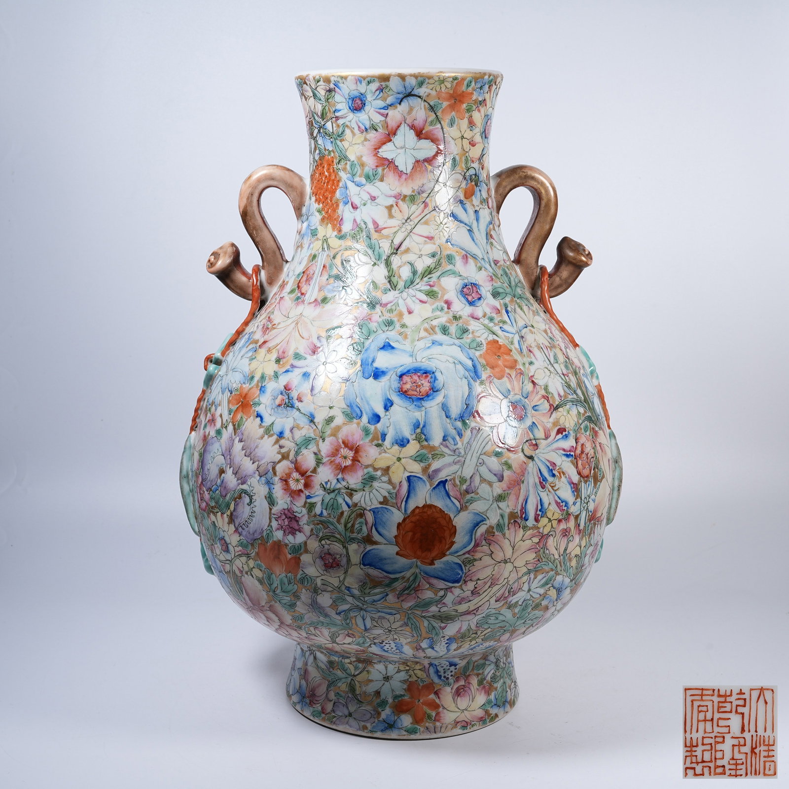 A FAMILLE ROSE RUYI-EARED ZUN VESSEL WITH ALL-OVER FLORAL PATTERNS: Famille Rose Ruyi-Eared Zun Vessel with All-Over Floral Patterns