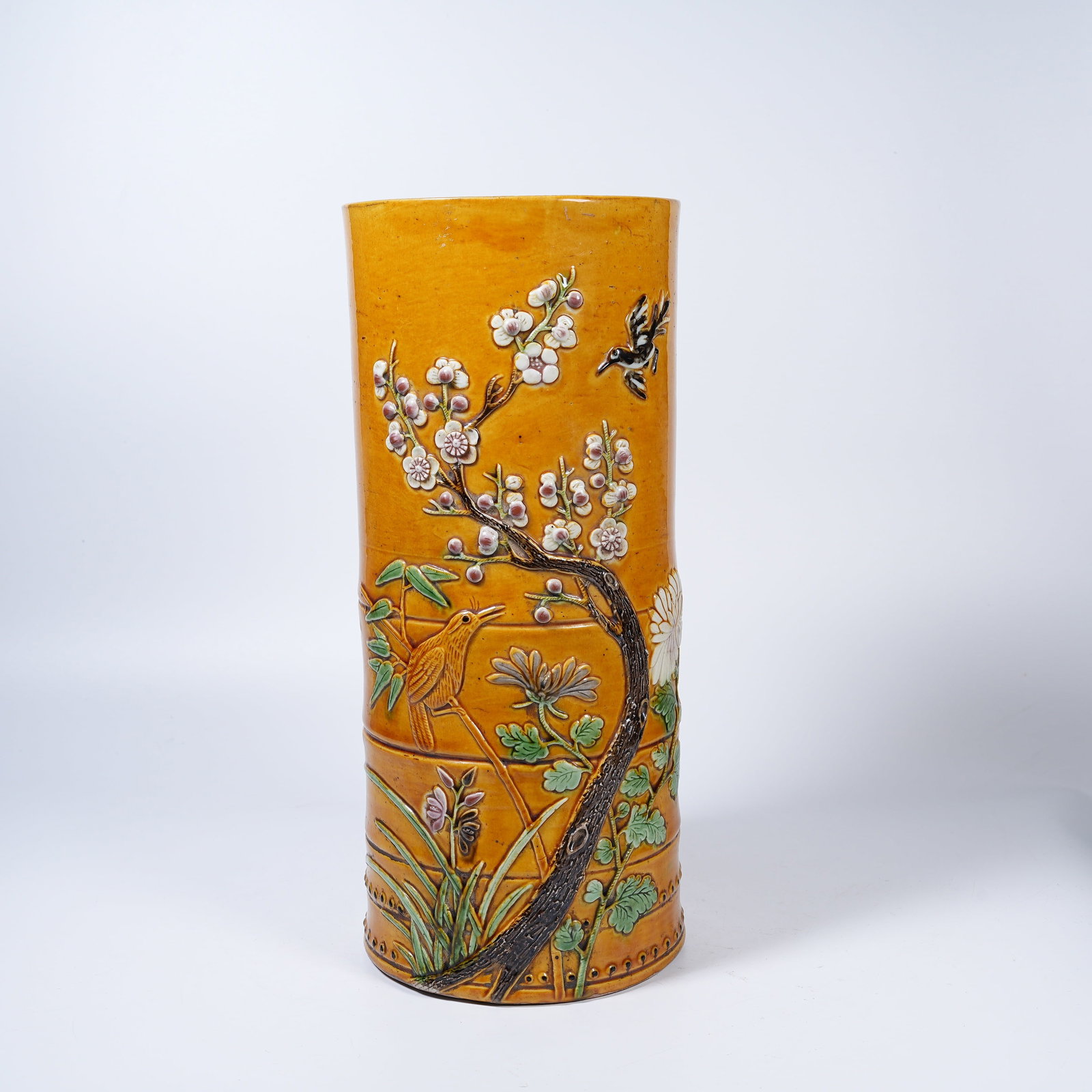 A YELLOW GROUND MOULDED FAMILLE ROSE HAT TUBE WITH FLOWER AND BIRD PATTERNS: Yellow Ground Moulded Famille Rose Hat Tube with Flower and Bird Patterns