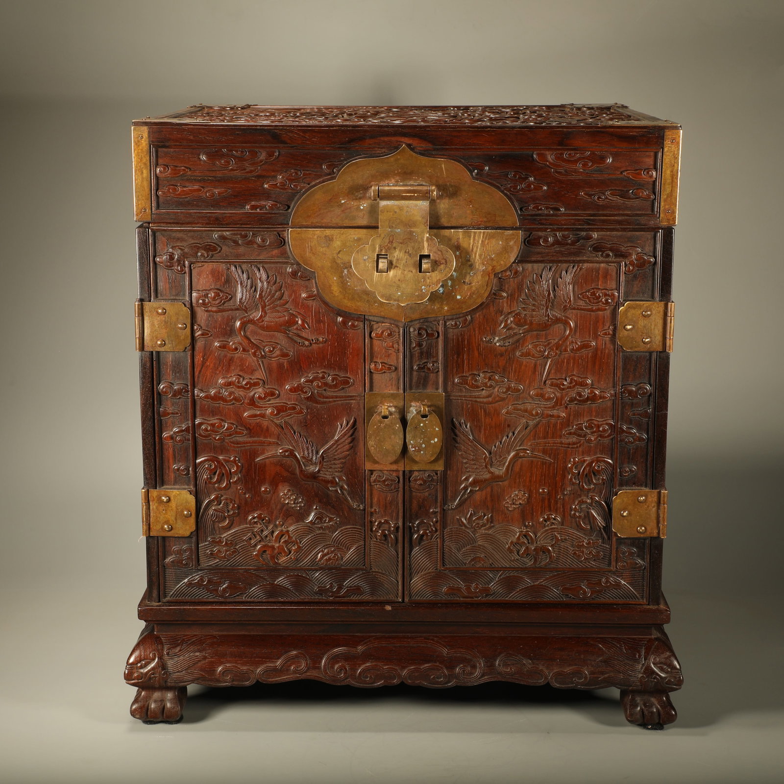 A PADAUK OFFICIAL LEATHER CHEST CARVED WITH CLOUD, CRANE AND EIGHT TREASURES PATTERNS: Padauk Official Leather Chest Carved with Cloud, Crane and Eight Treasures Patterns