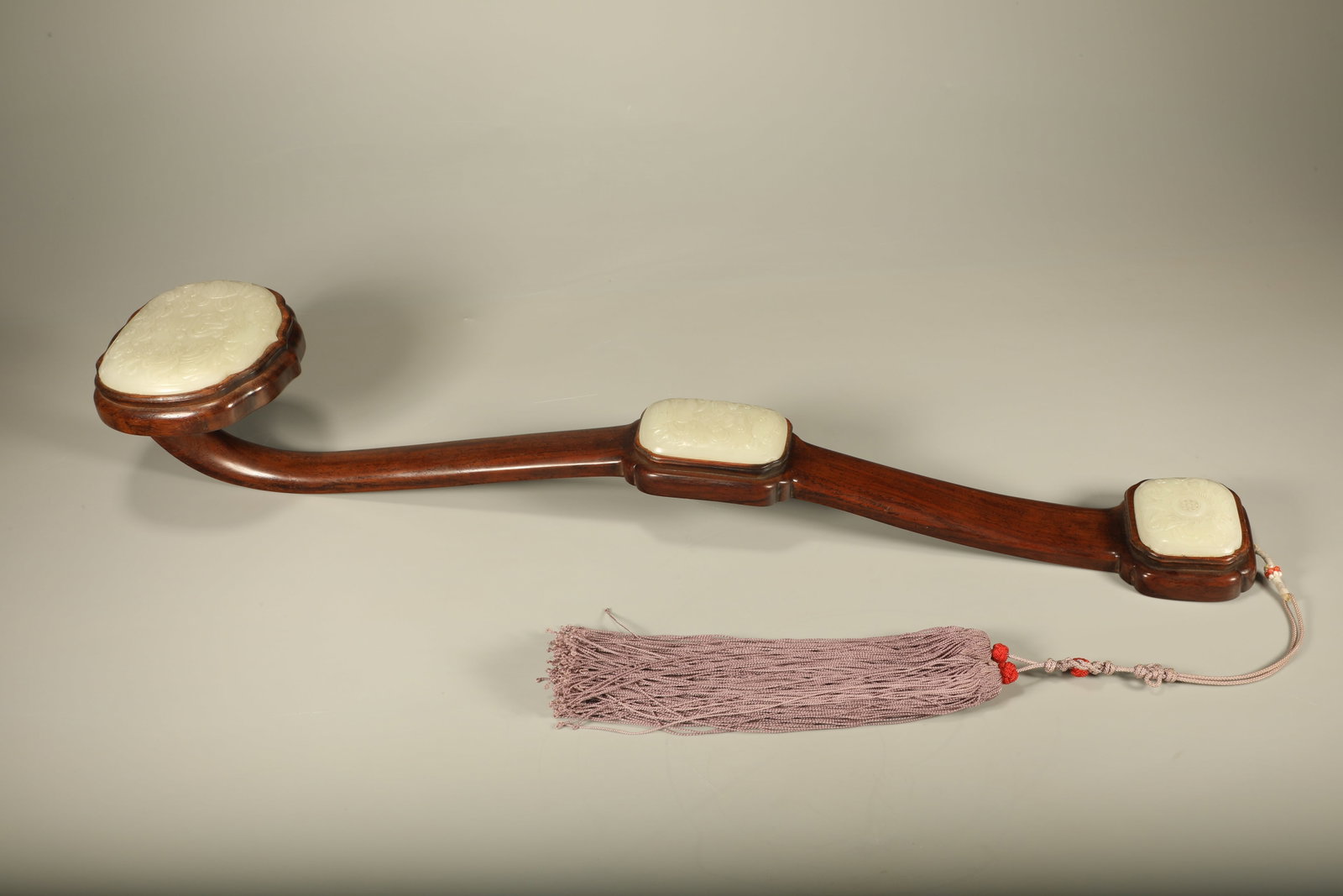 A PADAUK RUYI SCEPTER INLAID WITH JADE CARVED WITH EIGHT TREASURES AND LONGEVITY CHARACTER PATTERNS: Padauk Ruyi Scepter Inlaid with Jade Carved with Eight Treasures and Longevity Character Patterns