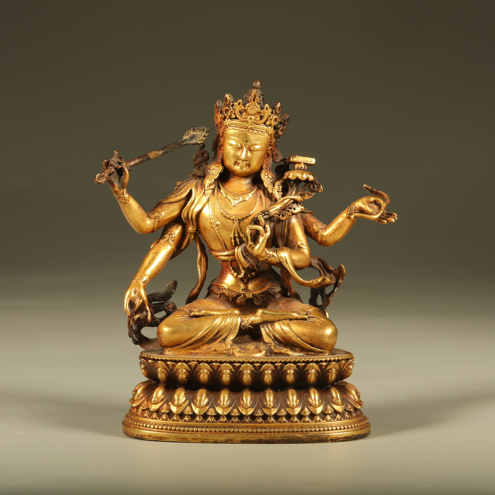 A GILT BRONZE STATUE OF FOUR-ARMED MANJUSHRI BODHISATTVA: Gilt Bronze Statue of Four-Armed Manjushri Bodhisattva