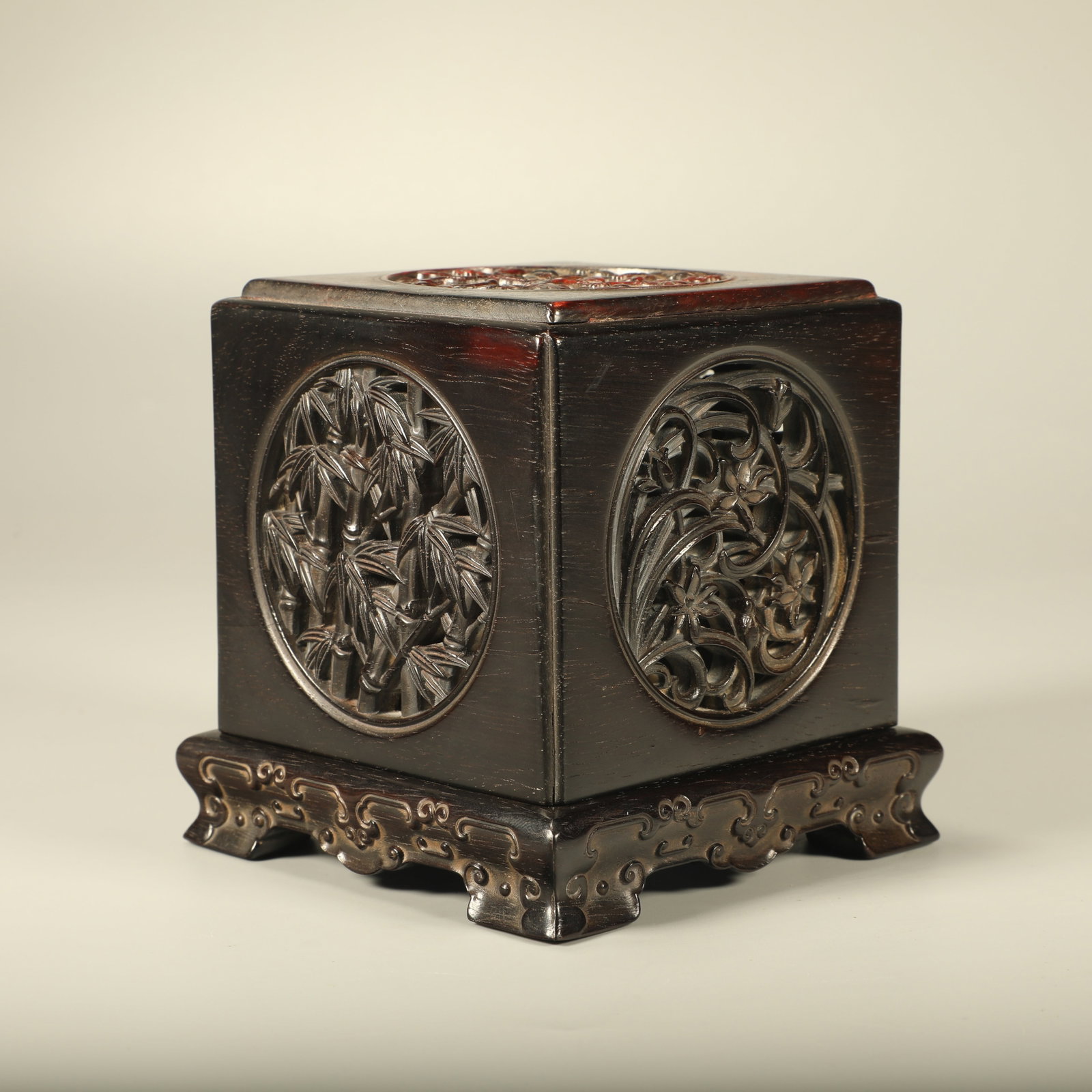 A OPENWORK RED SANDALWOOD SEAL BOX CARVED WITH PLUM, ORCHID, BAMBOO AND CHRYSANTHEMUM: Openwork Red Sandalwood Seal Box Carved with Plum, Orchid, Bamboo and Chrysanthemum