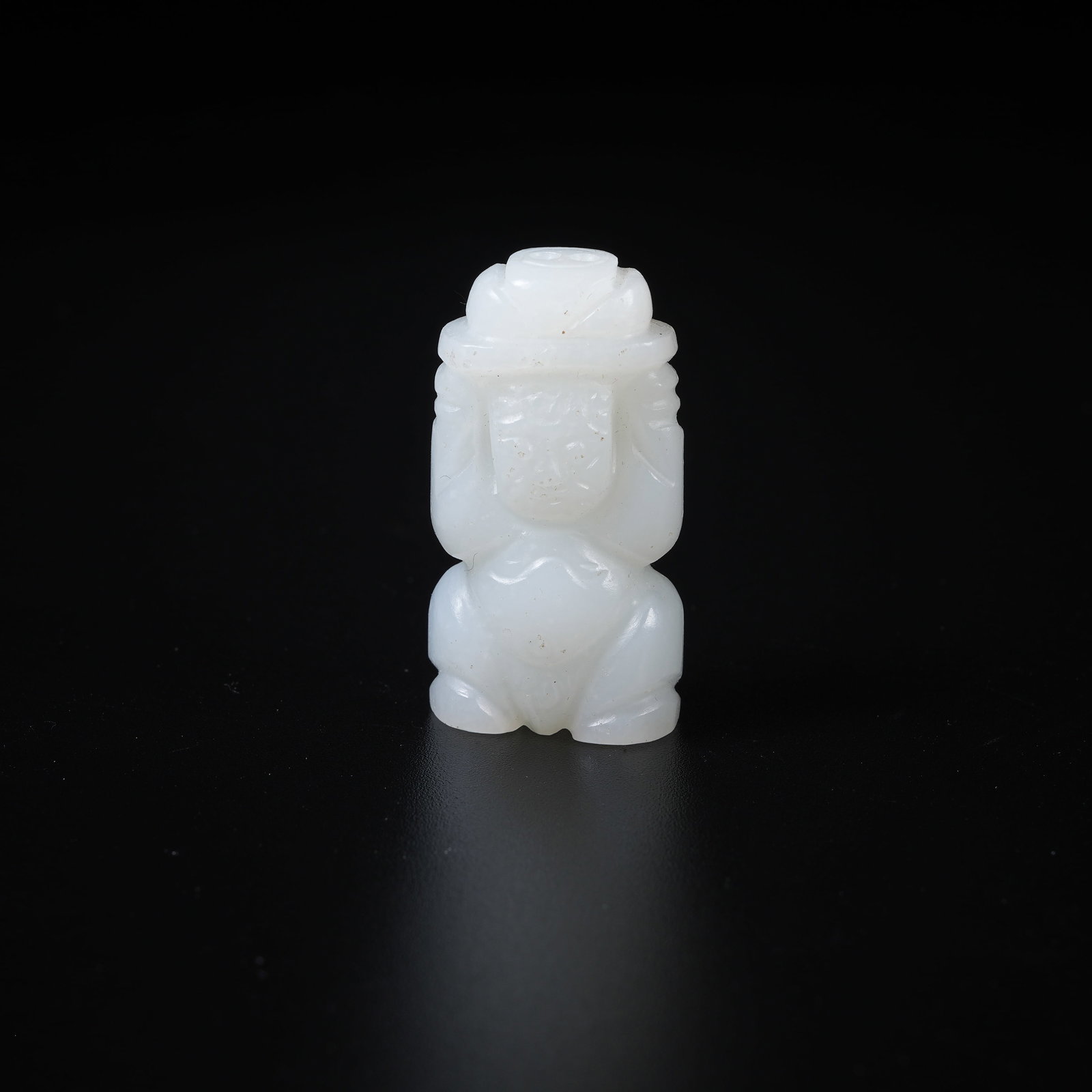 A WHITE HETIAN JADE HANGING ORNAMENT OF BOY PRESENTING TREASURES: White Hetian Jade Hanging Ornament of Boy Presenting Treasures