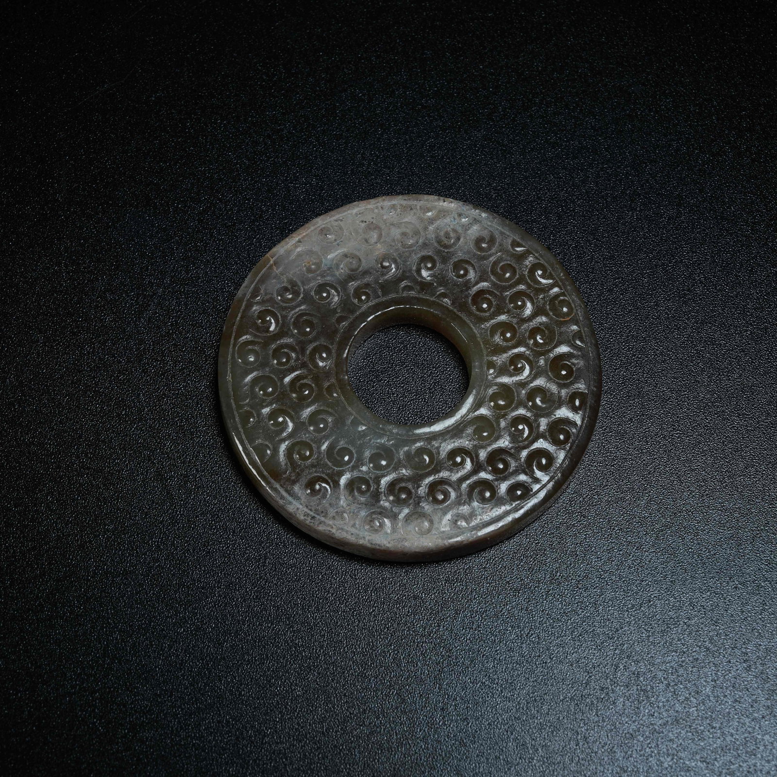 A SMALL CORDED ANCIENT JADE BI DISC WITH GRAIN PATTERNS: Small Corded Ancient Jade Bi Disc with Grain Patterns