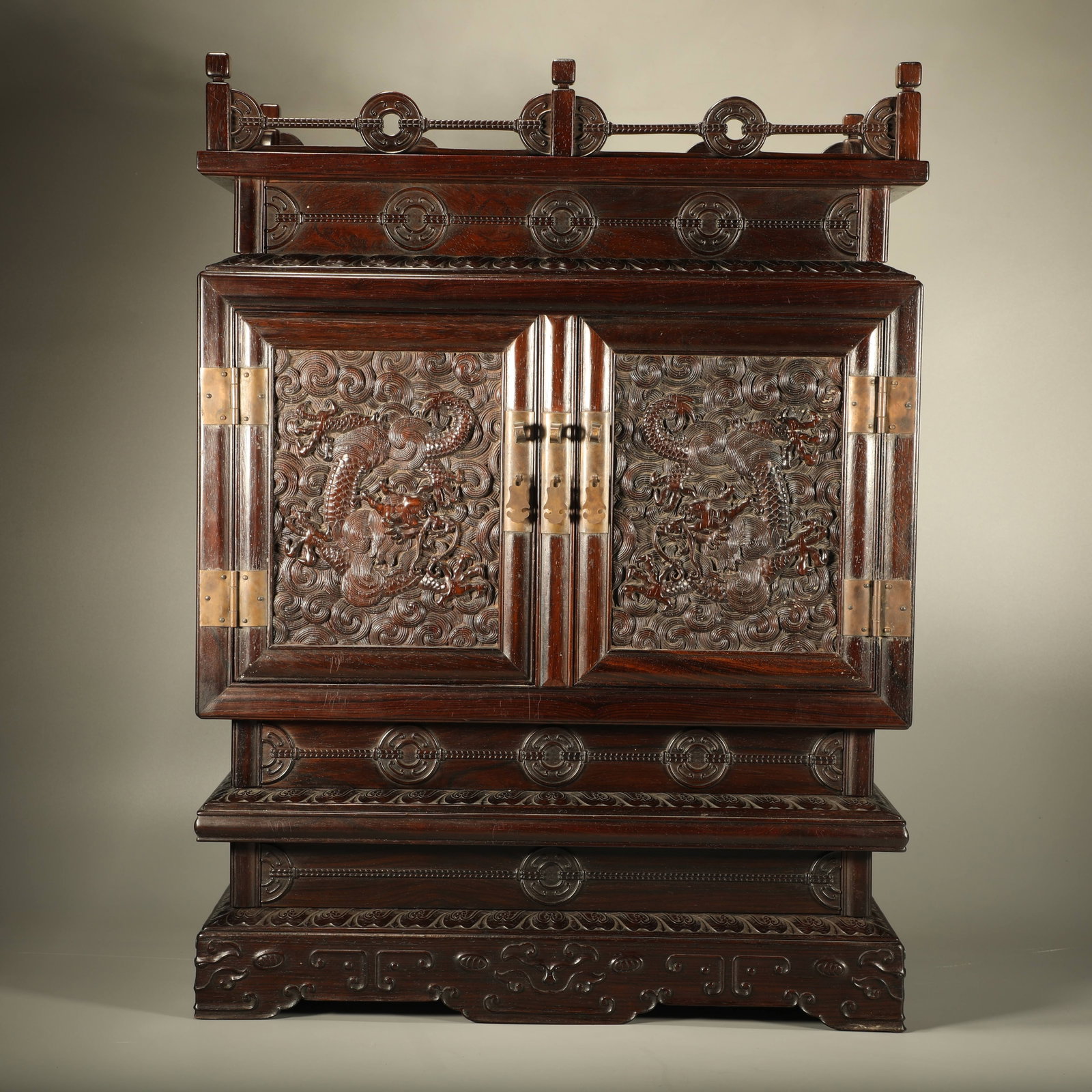 A RED SANDALWOOD BUDDHA CABINET CARVED WITH SEA WAVE AND DRAGON PATTERNS