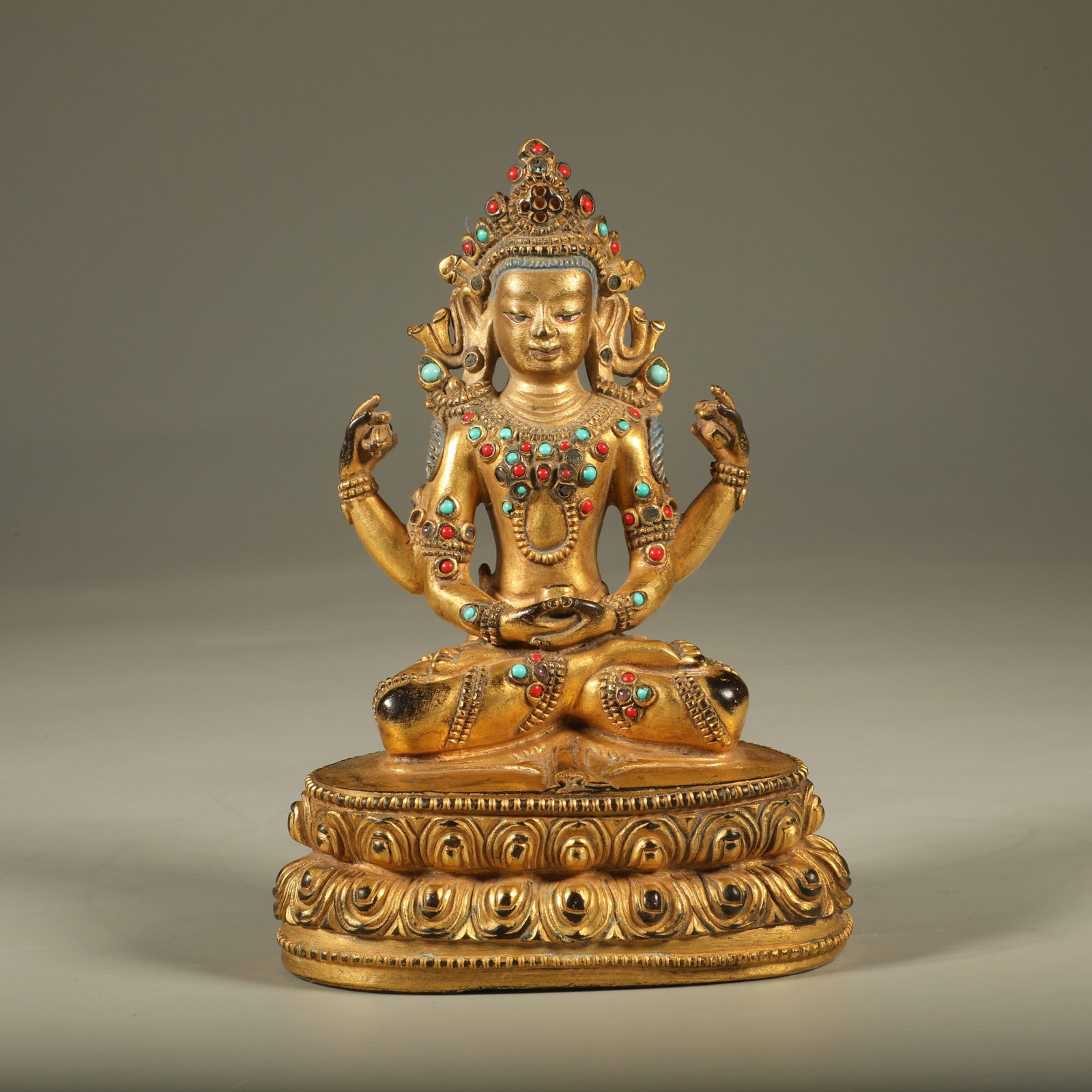A GEM-INLAID GILT BRONZE STATUE OF FOUR-ARMED GUANYIN: Gem-Inlaid Gilt Bronze Statue of Four-Armed Guanyin