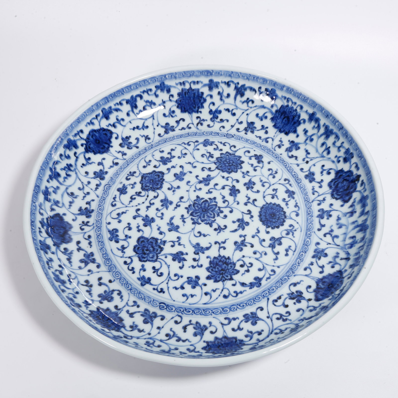 A LARGE BLUE AND WHITE PLATE WITH INTERLOCKING FLORAL PATTERN: Large Blue and White Plate with Interlocking Floral Pattern