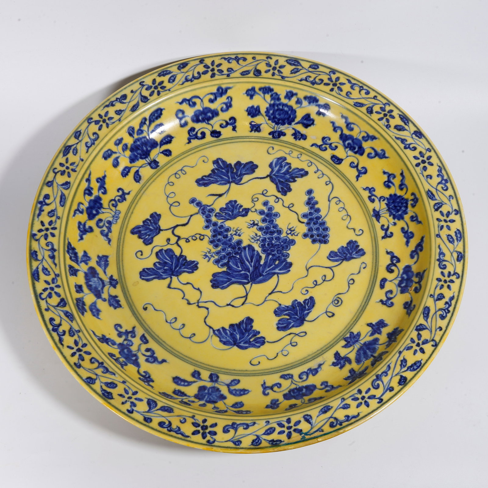 A BLUE AND WHITE PLATE WITH MELON AND FRUIT PATTERN ON YELLOW GROUND: Blue and White Plate with Melon and Fruit Pattern on Yellow Ground