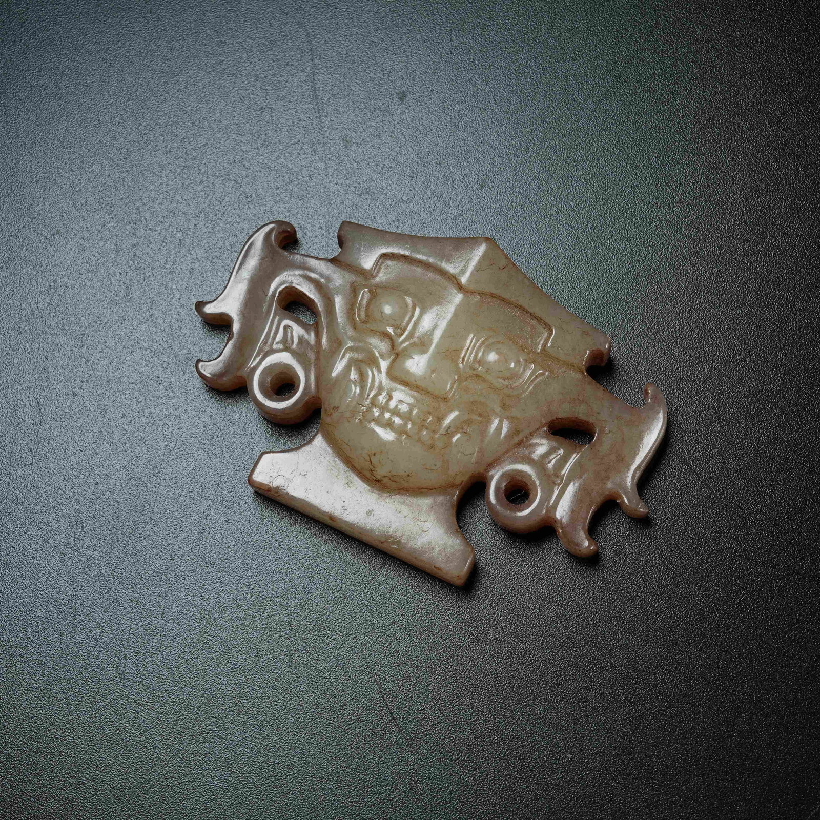 A ANCIENT JADE PENDANT CARVED WITH DIVINE HUMAN FACE MOTIFS: Ancient Jade Pendant Carved with Divine Human Face Motifs