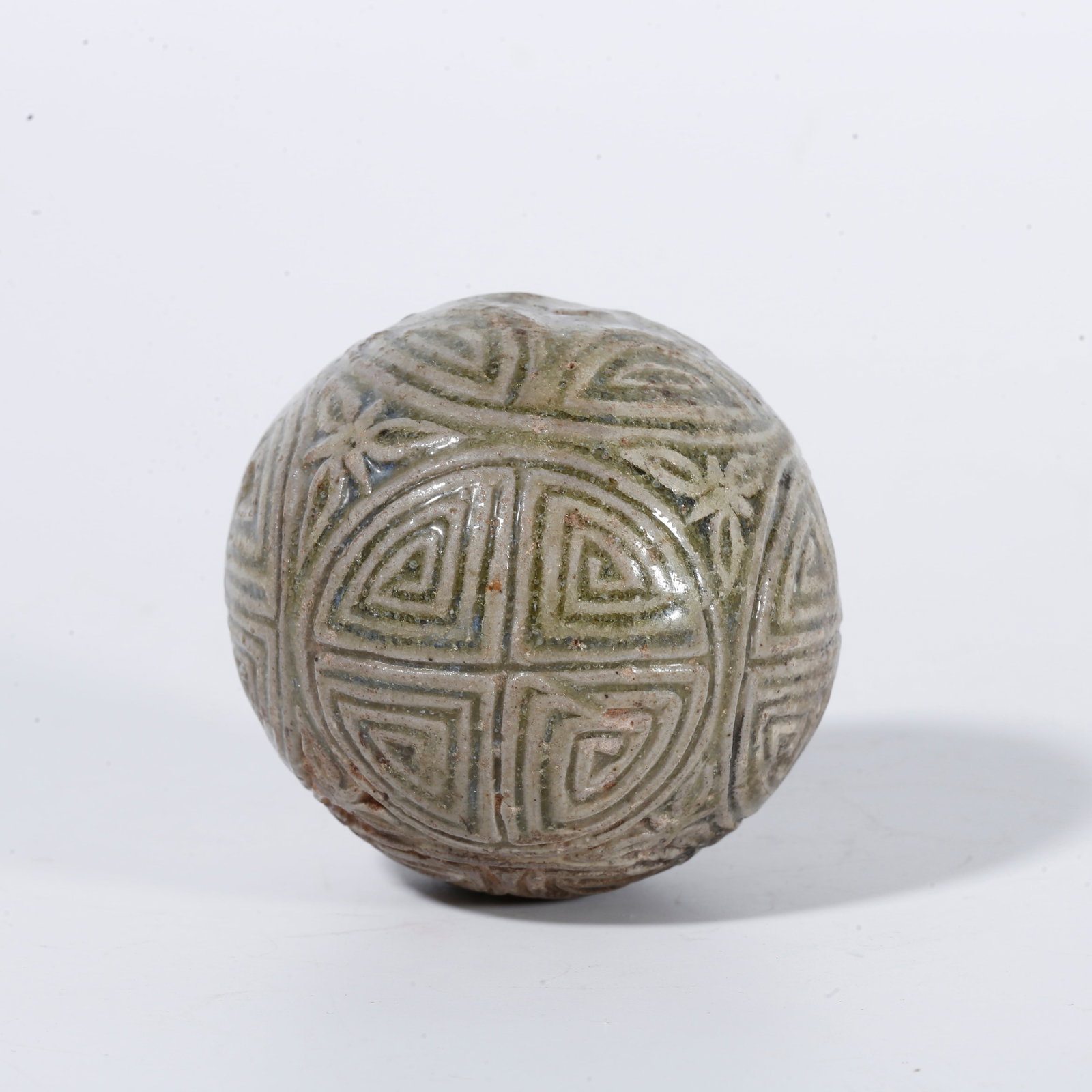 A CELADON SPHERE WITH SWASTIKA PATTERN: Celadon sphere with swastika pattern