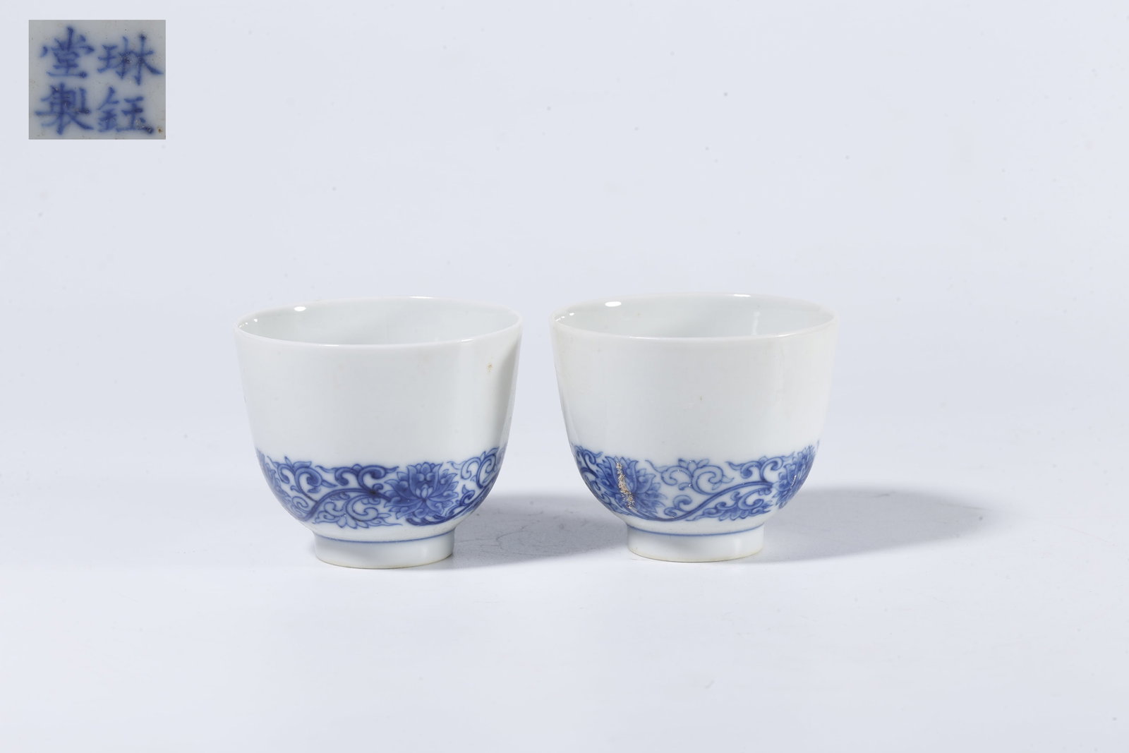 A PAIR OF BLUE-AND-WHITE CUPS WITH INTERLACED FLORAL SCROLLS: Pair of Blue-and-White Cups with Interlaced Floral Scrolls