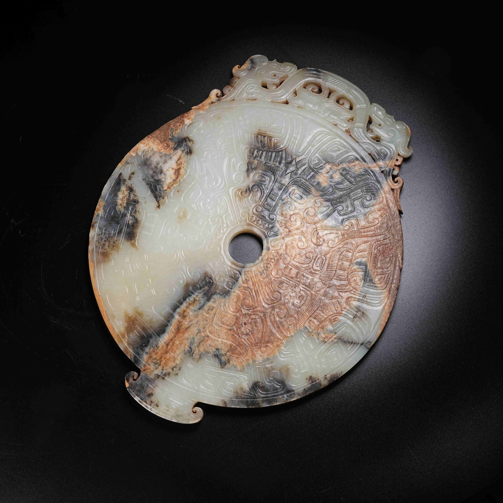 A ANCIENT JADE BI DISC WITH OUTER CARVED DIVINE MASKS: Ancient Jade Bi Disc with Outer Carved Divine Masks