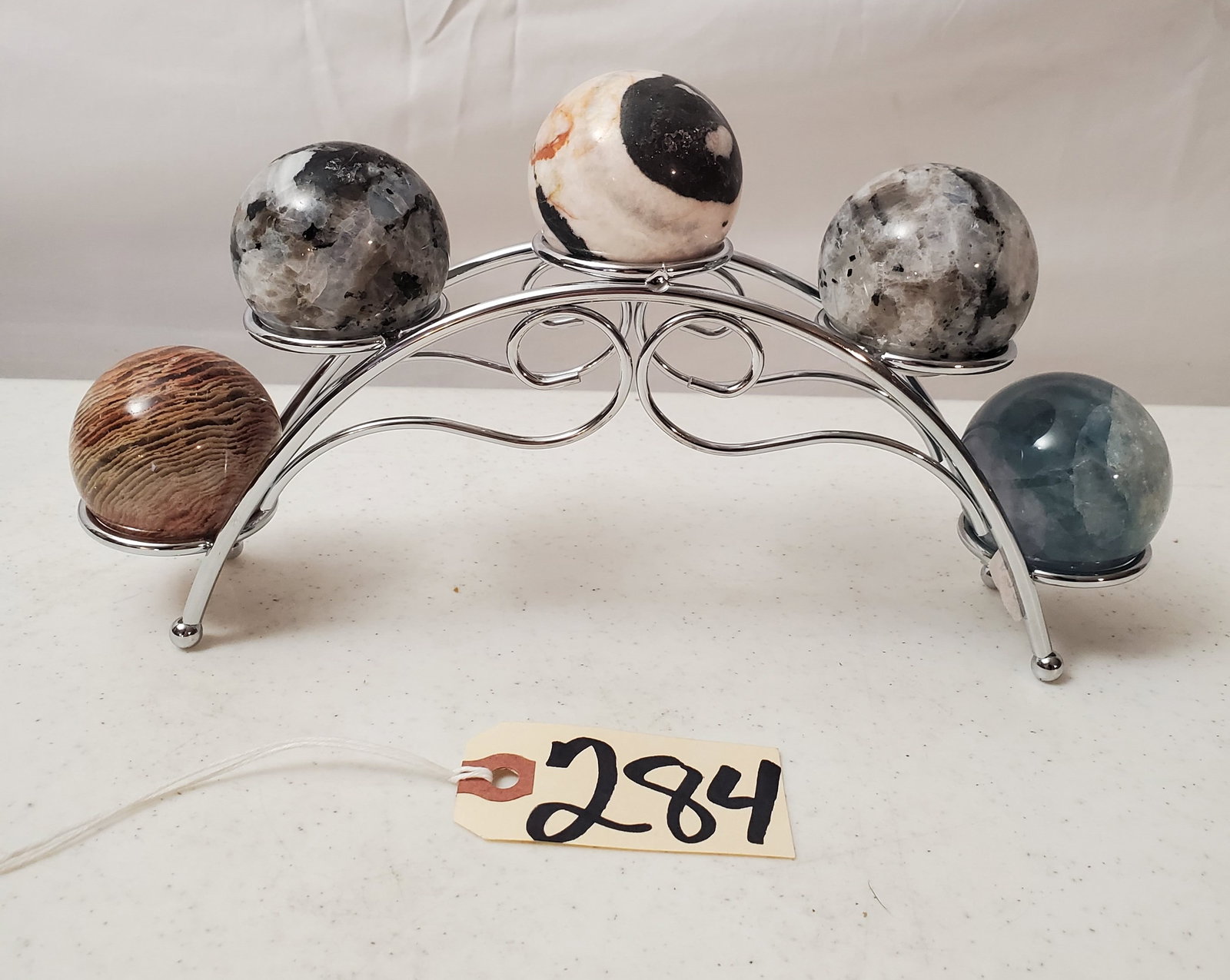 DECORATIVE DISPLAY OF 5 NATURAL STONE SPHERES ON METAL STAND: DISPLAYING GREAT COLORS, SHERES MEASURING 3" IN DIAMETER, STAND IS 10" LONG