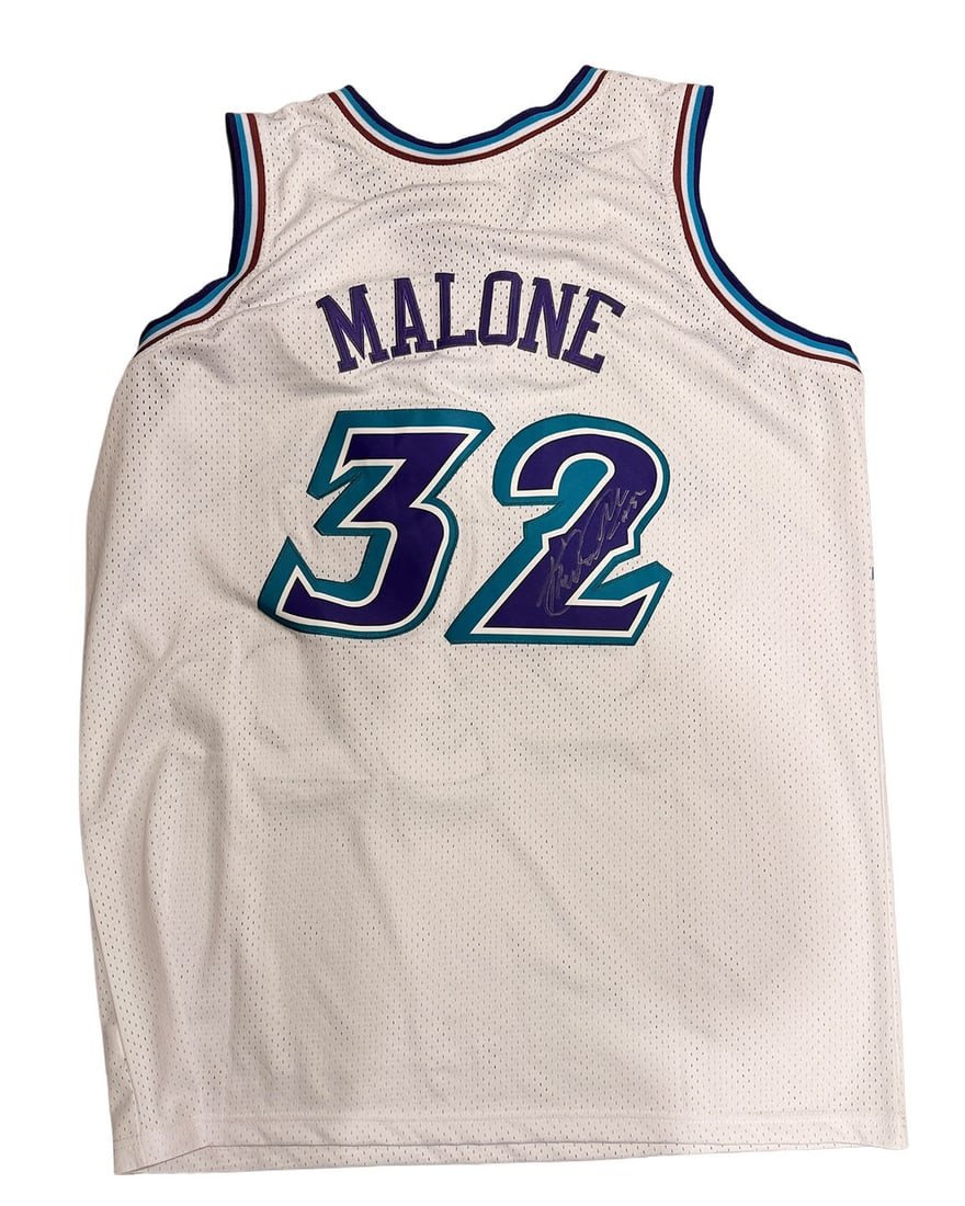 Karl Malone Autographed Jersey Jazz: The Mailman Autographed White Jazz Jersey. Signed in white pen. Autograph is a bit light.