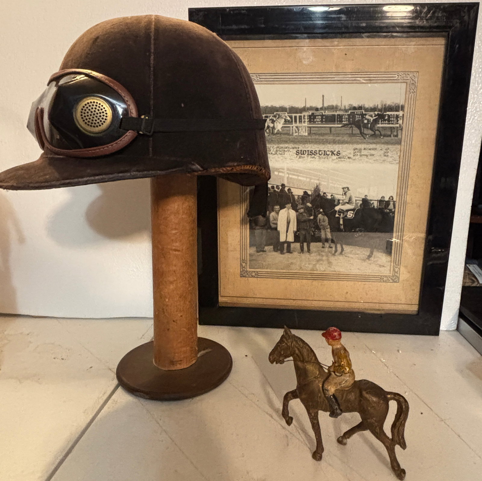Horse Racing small Collection Hat Goggles Ect: Horse Racing small Collection, Hat on an antique spool as a stand, Goggles a Framed 12"x16" Swiss Ticks Racing photo, and a small cast iron Horse and Jockey. Nice lot of Horse racing decor all