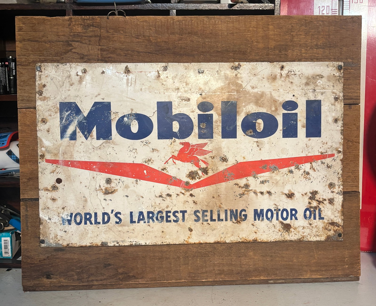 1940s50s Mobiloil Patina Tin Tacker sign mounted on Barnwood: Up for auction is an authentic slice of mid-century American petroliana: a vintage Mobiloil "World's Largest Selling Motor Oil" single-sided tin (SST) advertising sign. Featuring the iconic red Pegasu