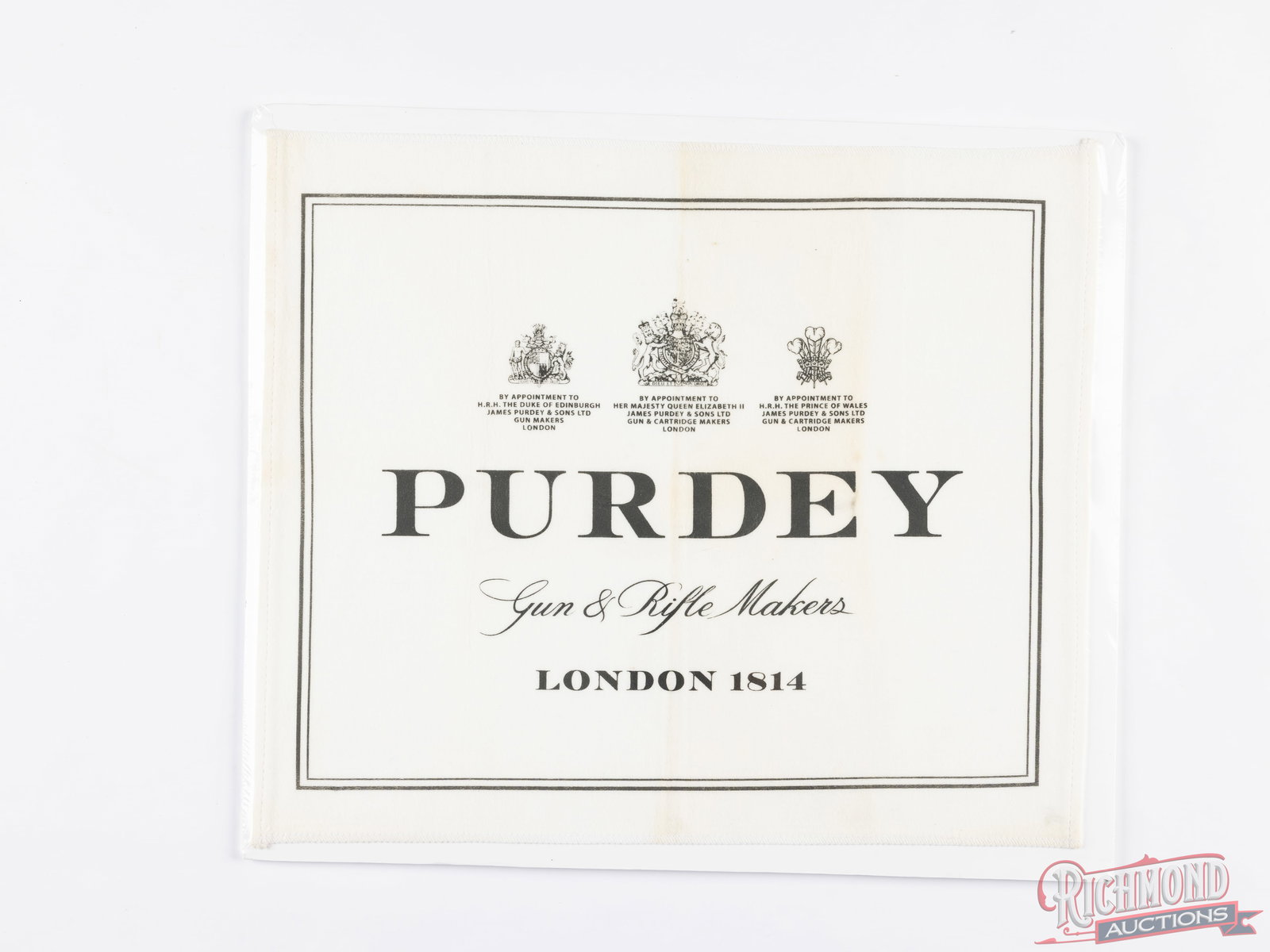 Purdey London 1814 Gun & Rifle Makers Selvyt Gun Cleaning Cloth: White Selvyt cleaning cloth measuring 16-1/2" x 14" with Purdey Gun and Rifle Makers, London 1814 advertising in black print. Shrink-wrapped to a foam board. Unknown age and origin.ConditionGOOD -