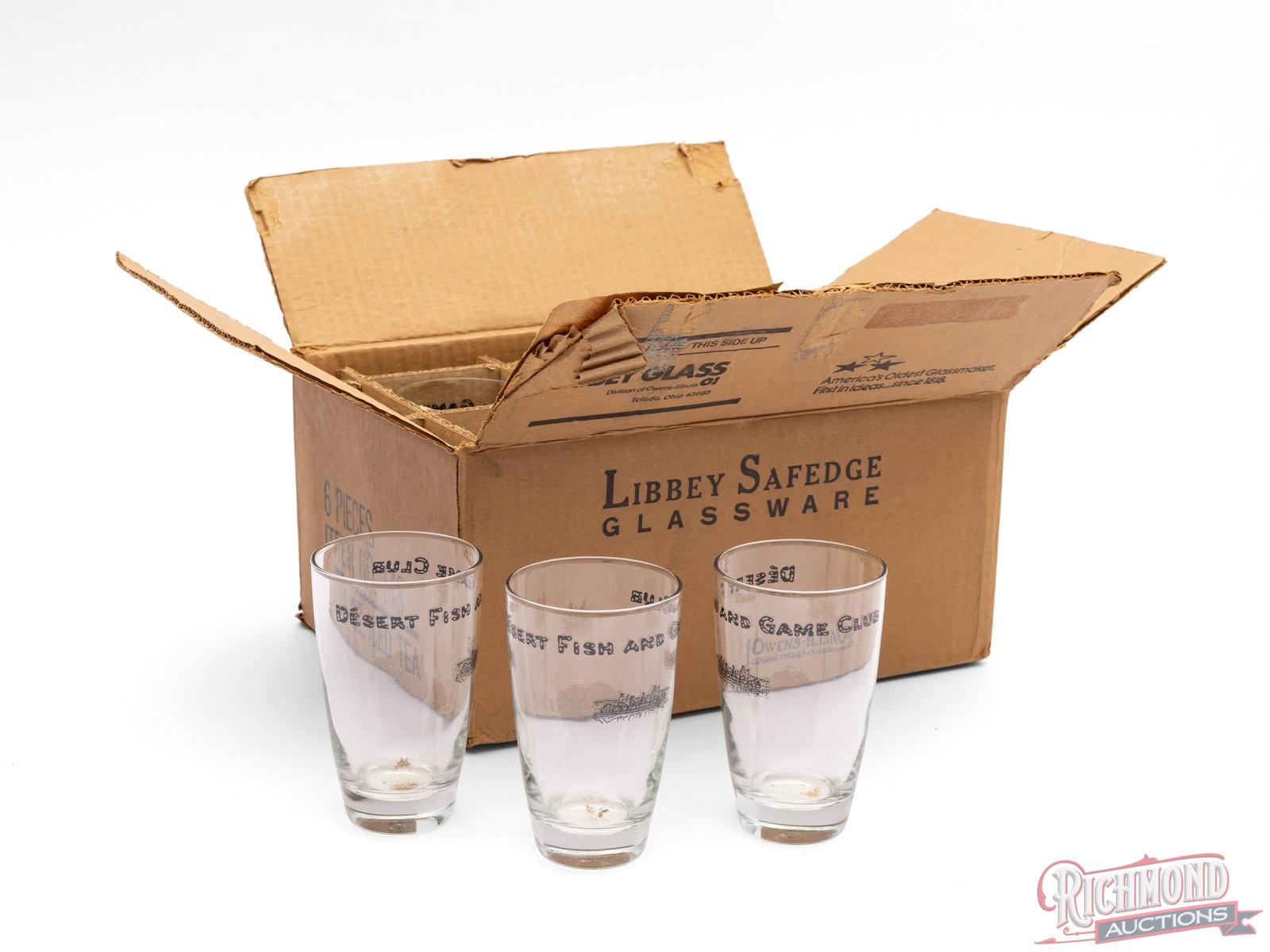 Set of 6 Glasses "Desert Fish And Game Club": This is a case of 6 glasses that feature "Desert Fish and Game Club" with the graphic of a group of men in a canoe. Condition VERY GOOD