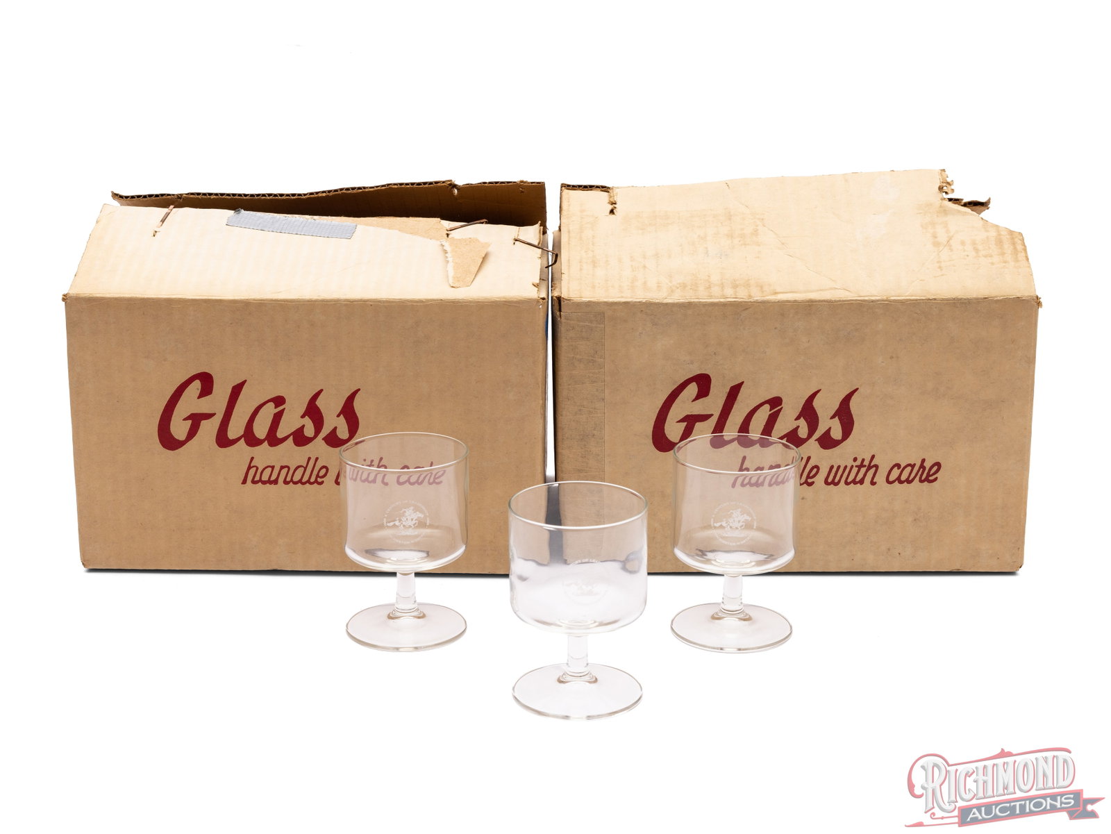 Set of 12 Winchester 100th Anniversary Stemmed Glasses: In this lot is two cases of Winchester 100th Anniversary stemmed glasses. Each case contains 6 glasses that stand 4 1/4" tall. Each glass has The engraving of the Winchester-Western logo with "A Centu
