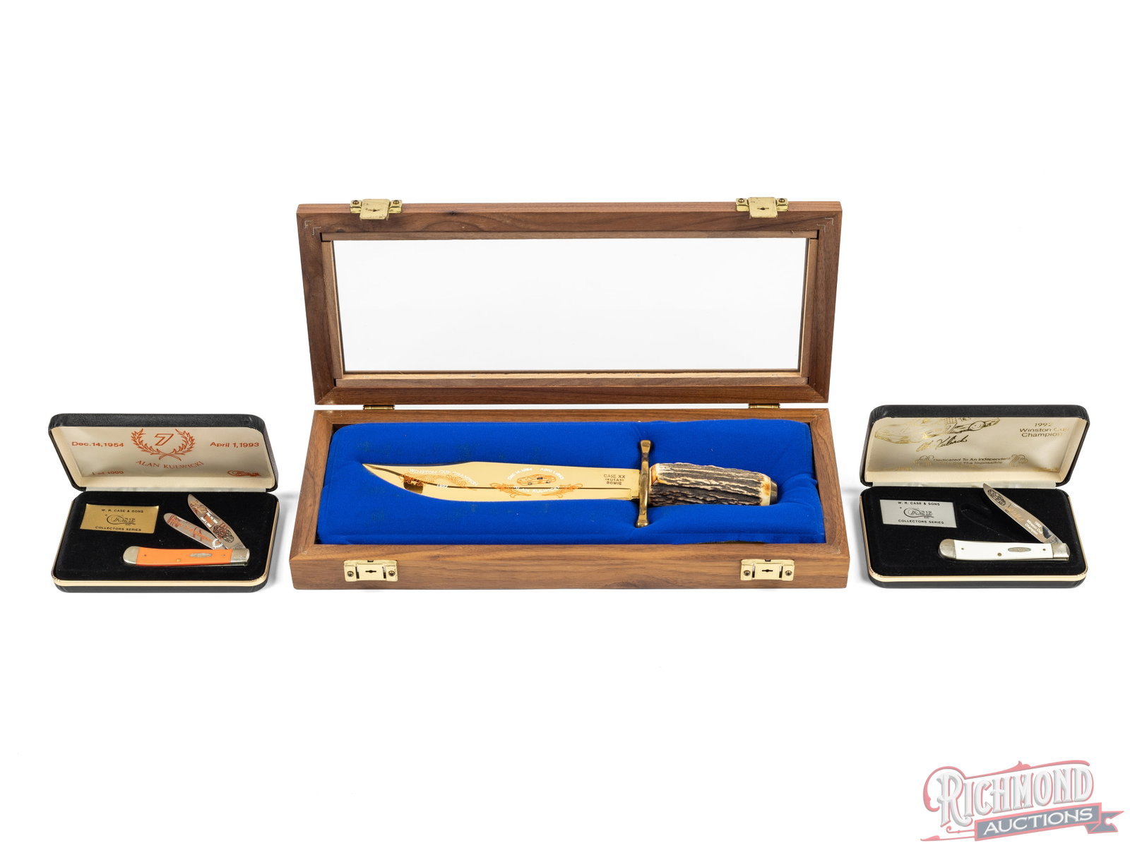 Case XX Fixed Blade Bowie and Two Trapper Folder Knives Alan Kulwicki Commemorative: This lot includes three Case XX brand knives commemorating Nascar driver Alan Kulwicki. All come in their original cases. One gold washed blade bowie stamped 1992 with double brass hilt and large roun