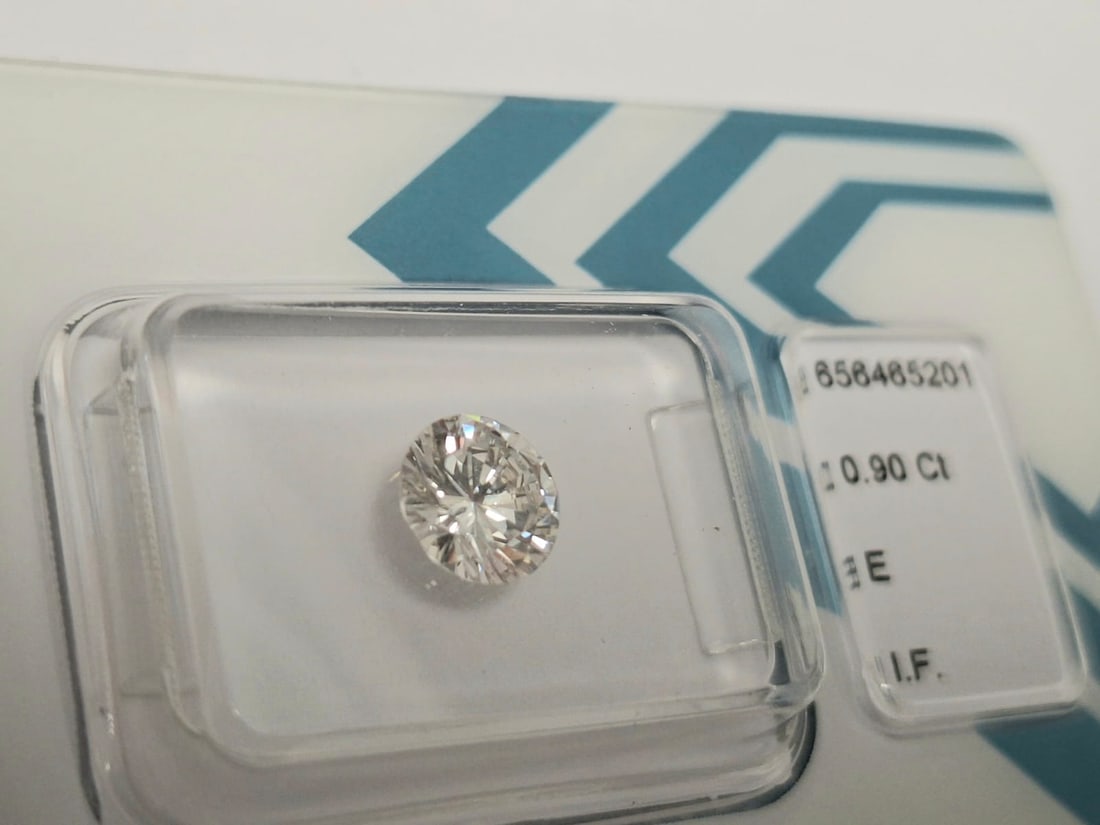 1 pcs Diamond (Natural) - 0.90 Carat - Round - E - IF - International Gemological Institute (IGI): This 0.90-carat natural diamond represents a rare combination of technical purity and elite color.Report Number: 656465201.Type: Natural Diamond.Shape and Cutting Style: Round Brilliant.Carat Weight: